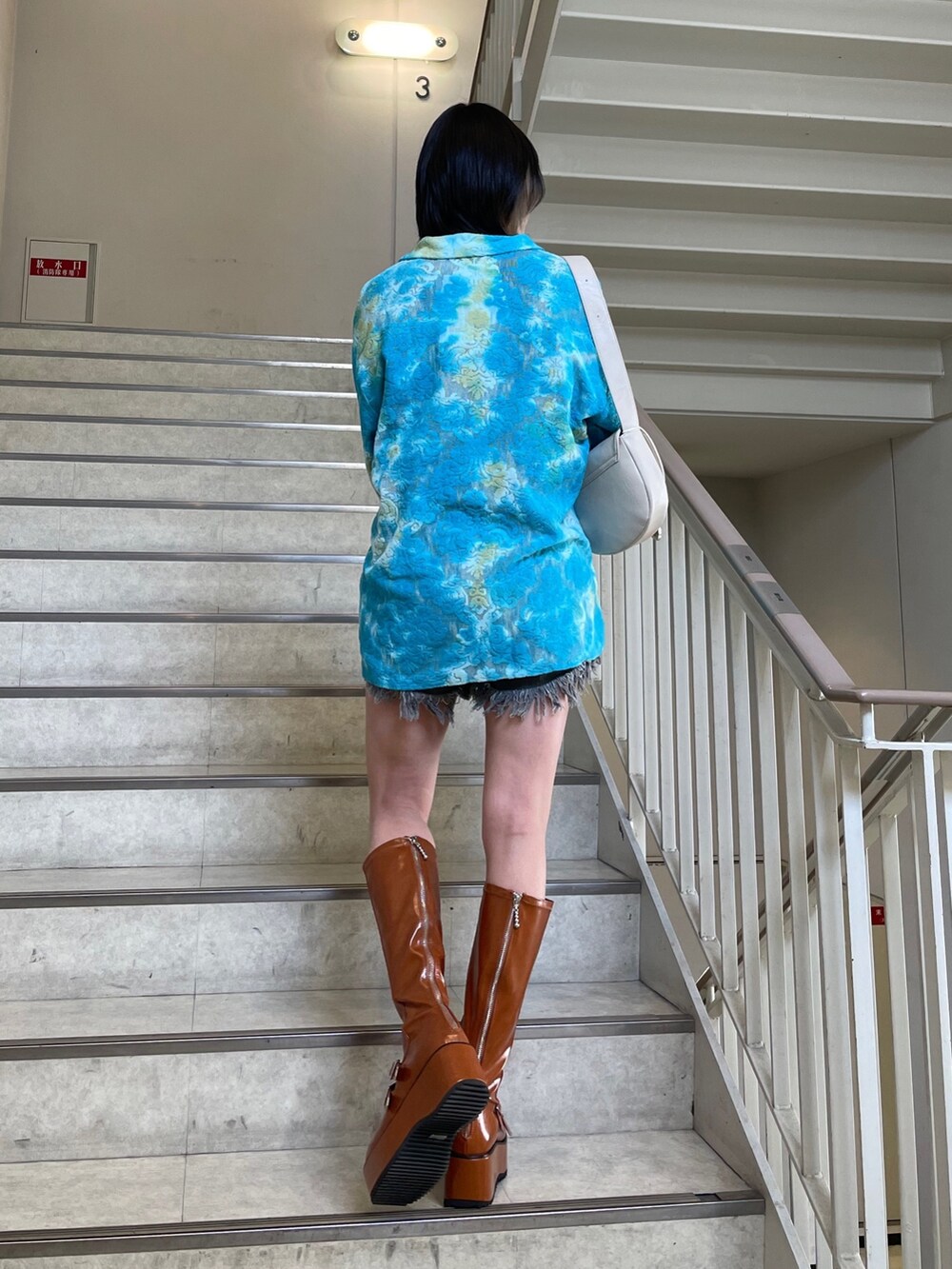 ブラック系のデニムパンツ、ブルー系のシャツ/ブラウス、ブラック系のTシャツ/カットソーを着用したレディースの春コーディネートの7枚目の写真