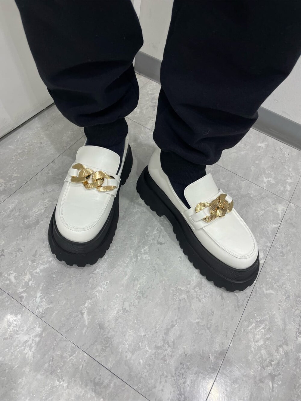 ブラック系のスウェットパンツ、ホワイト系のその他シューズ、ブルー系のニット/セーターを着用したレディースの春コーディネートの5枚目の写真