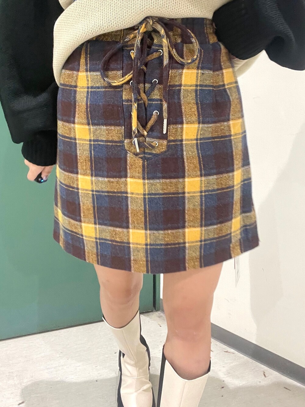 ブラック系のその他アウター、イエロー系のスカート、ホワイト系のブーツを着用したレディースの秋コーディネートの10枚目の写真