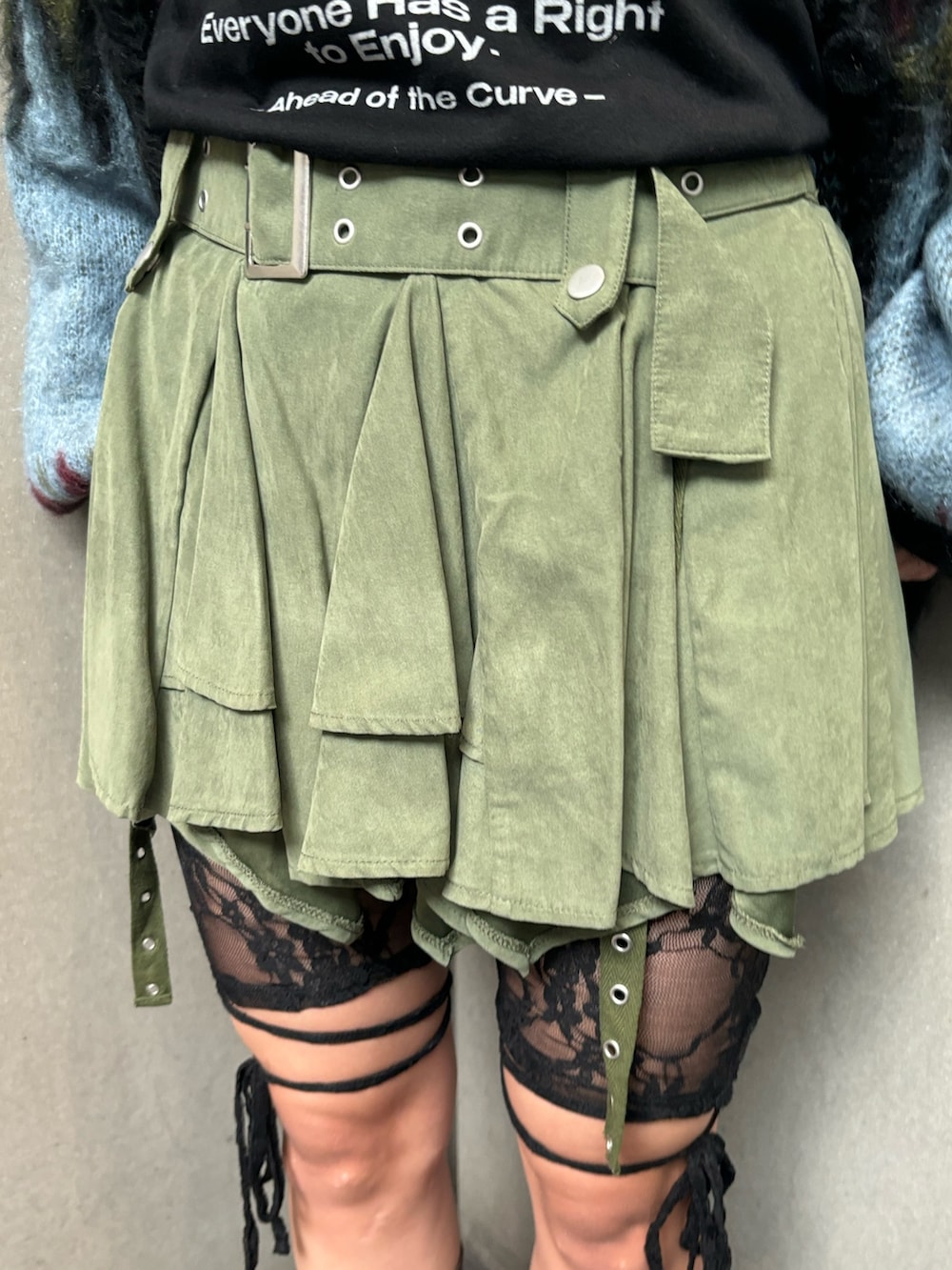 ブラック系のTシャツ/カットソー、ブラック系のカーディガン/ボレロ、グリーン系のスカートを着用したレディースの秋コーディネートの8枚目の写真