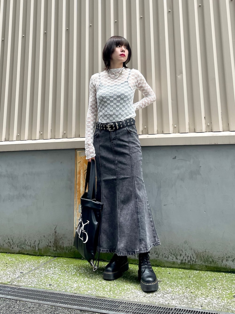 ホワイト系のTシャツ/カットソー、ブラック系のバックパック/リュック、ブラック系のデニムスカートを着用したレディースの夏コーディネートの3枚目の写真