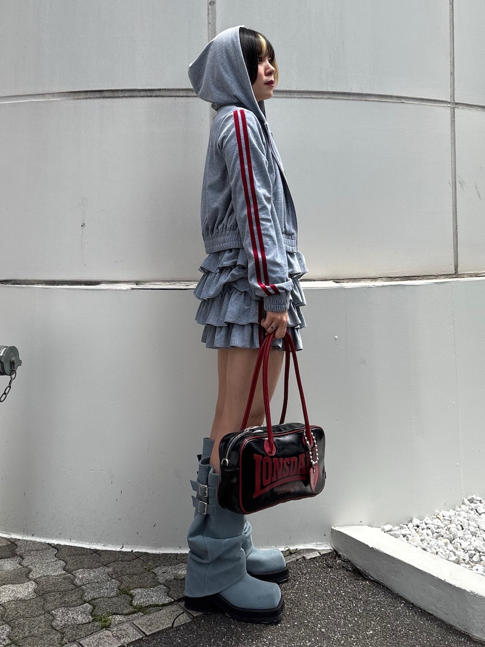 ブラック系のボストンバッグ、ブルー系のブーツ、ブラック系のTシャツ/カットソーを着用したレディースの春コーディネートの3枚目の写真