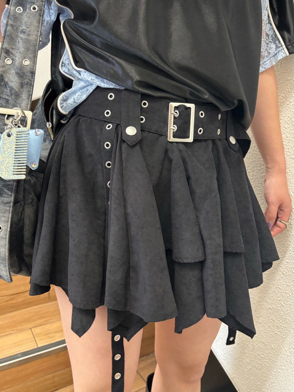 ブラック系のスカート、ブラック系のメッセンジャーバッグ、ブラック系のTシャツ/カットソーを着用したレディースの春コーディネートの7枚目の写真