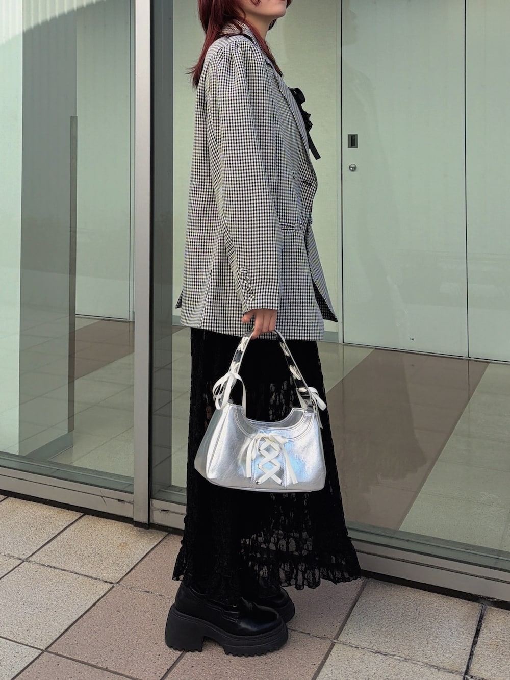 ブラック系のワンピース、ブラック系のテーラードジャケット、シルバー系のハンドバッグを着用したレディースの冬コーディネートの3枚目の写真