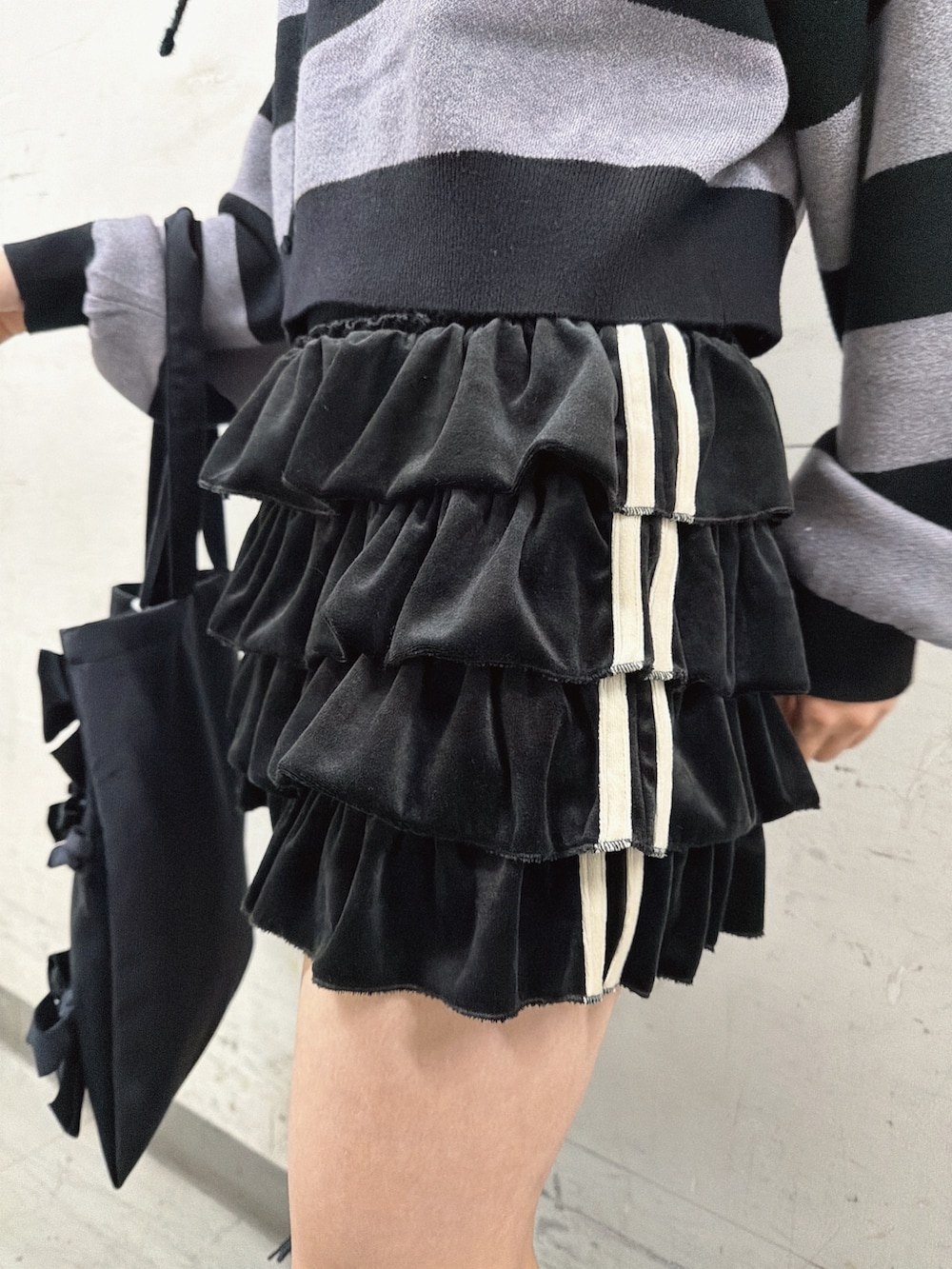 ブラック系のスカート、その他のニット/セーター、ブラック系のブーツを着用したレディースの秋コーディネートの7枚目の写真