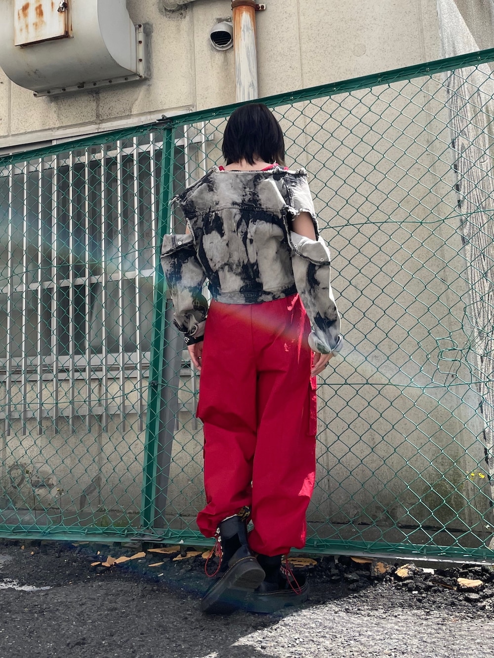 レッド系のカーゴパンツ、ブラック系のブーツ、ブラック系のデニムジャケットを着用したレディースの春コーディネートの9枚目の写真