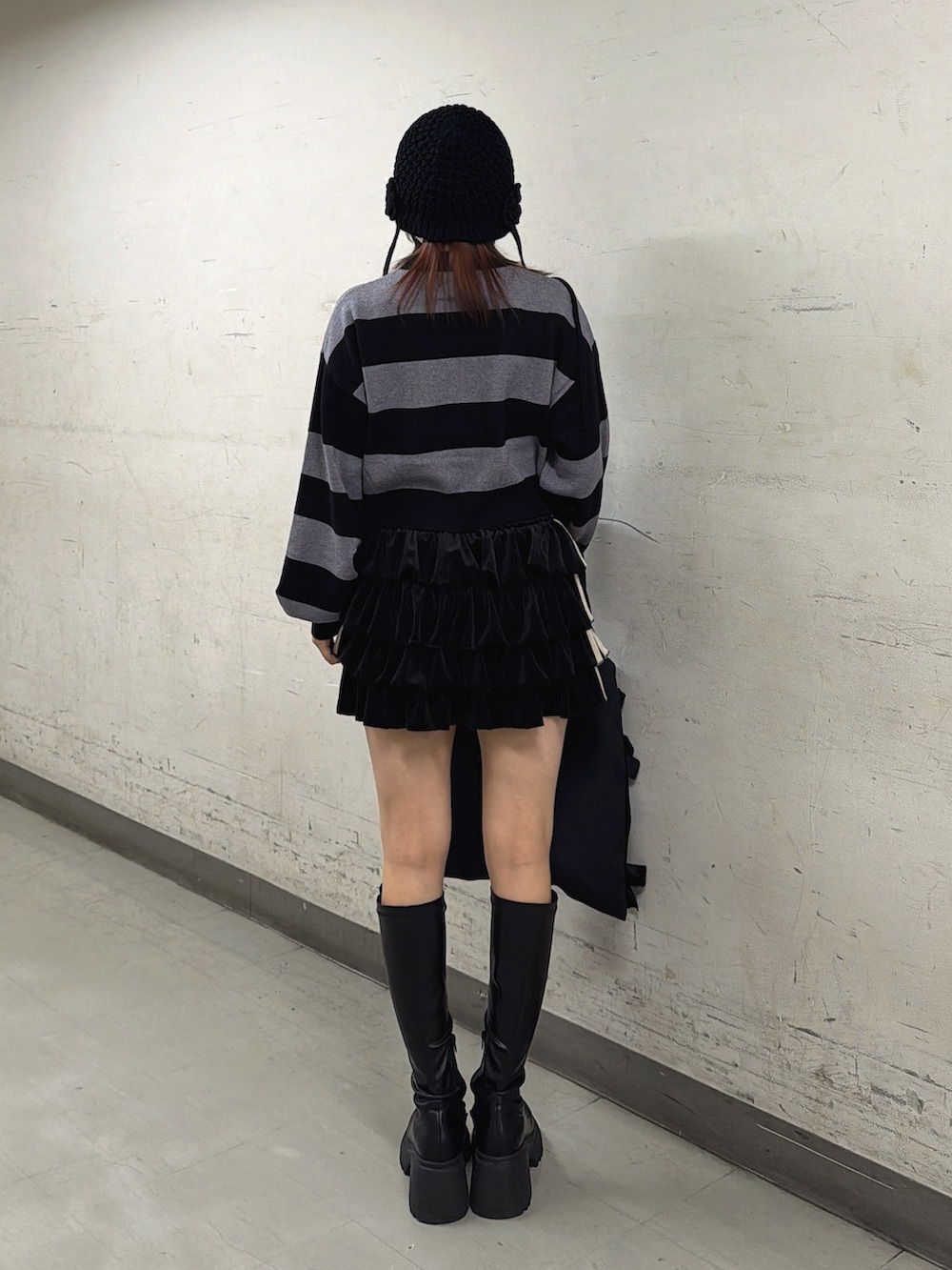 ブラック系のスカート、その他のニット/セーター、ブラック系のブーツを着用したレディースの秋コーディネートの4枚目の写真