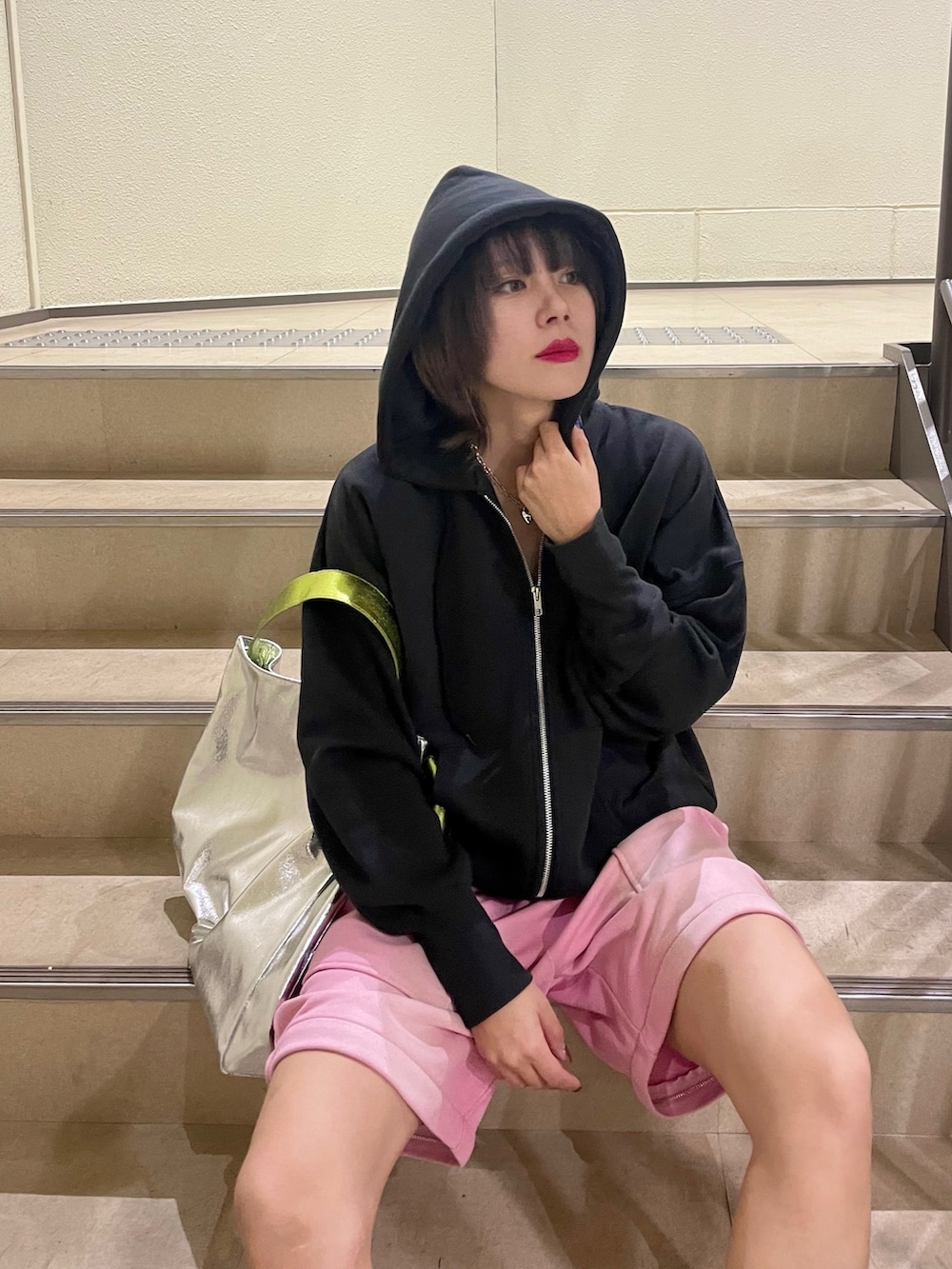 シルバー系のトートバッグ、ピンク系のスウェットパンツ、ブラック系のパーカーを着用したレディースの冬コーディネートの7枚目の写真