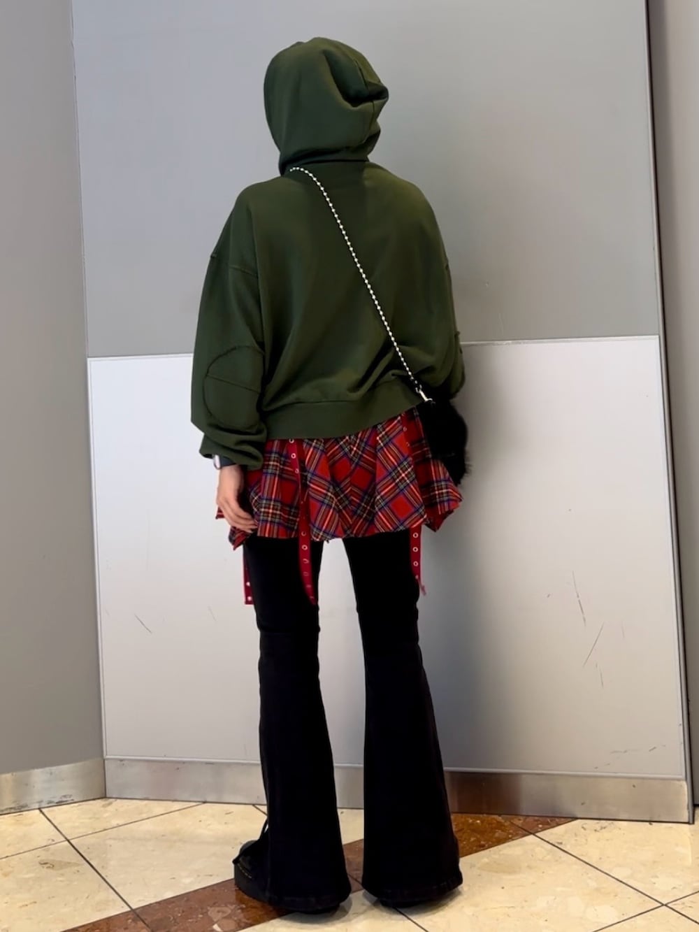 ブラック系のハンドバッグ、ブラック系のデニムパンツ、グリーン系のパーカーを着用したレディースの秋コーディネートの5枚目の写真