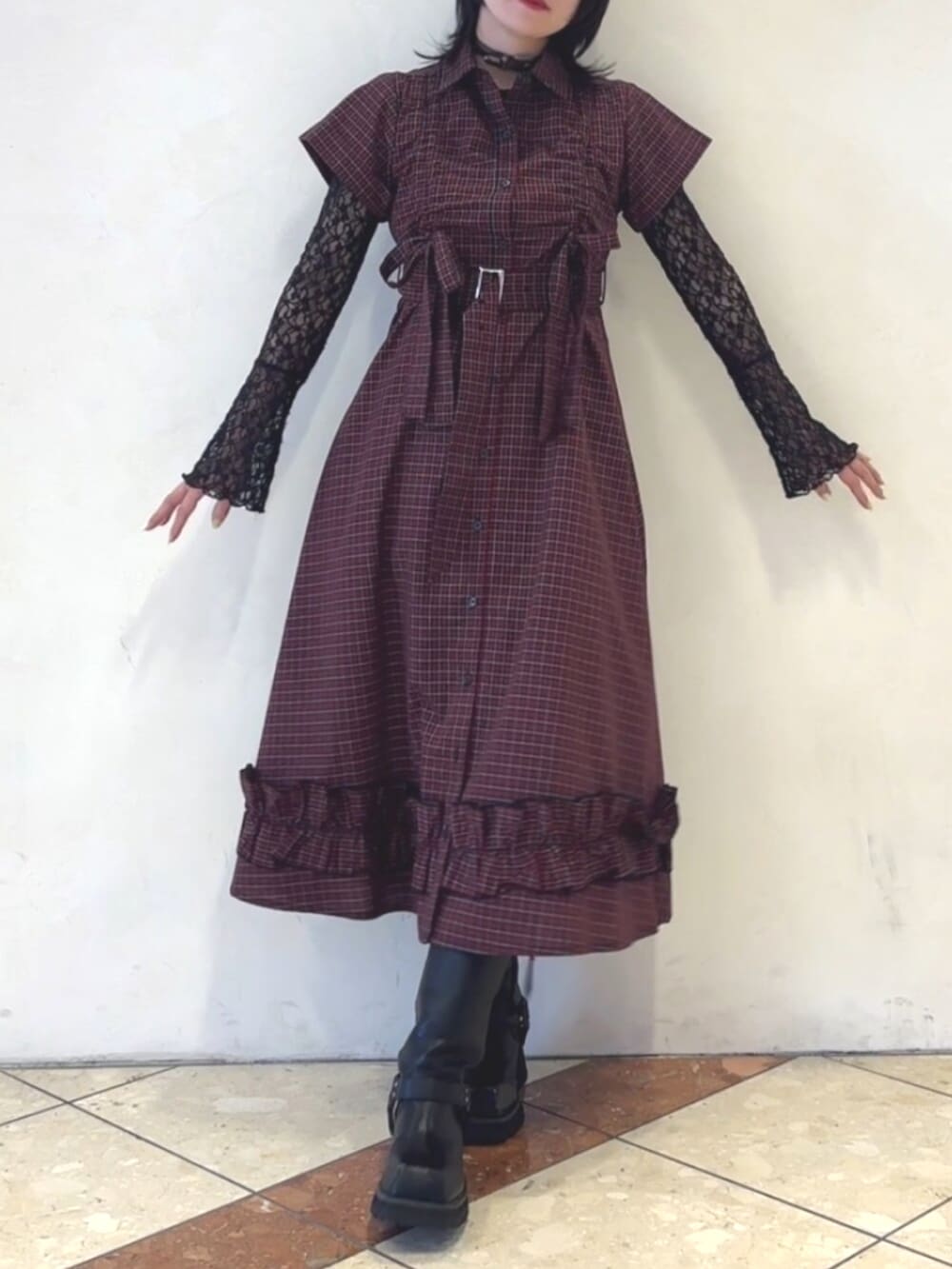 レッド系のワンピース、ブラック系のTシャツ/カットソー、ブラウン系のチョーカーを着用したレディースの春コーディネートの2枚目の写真