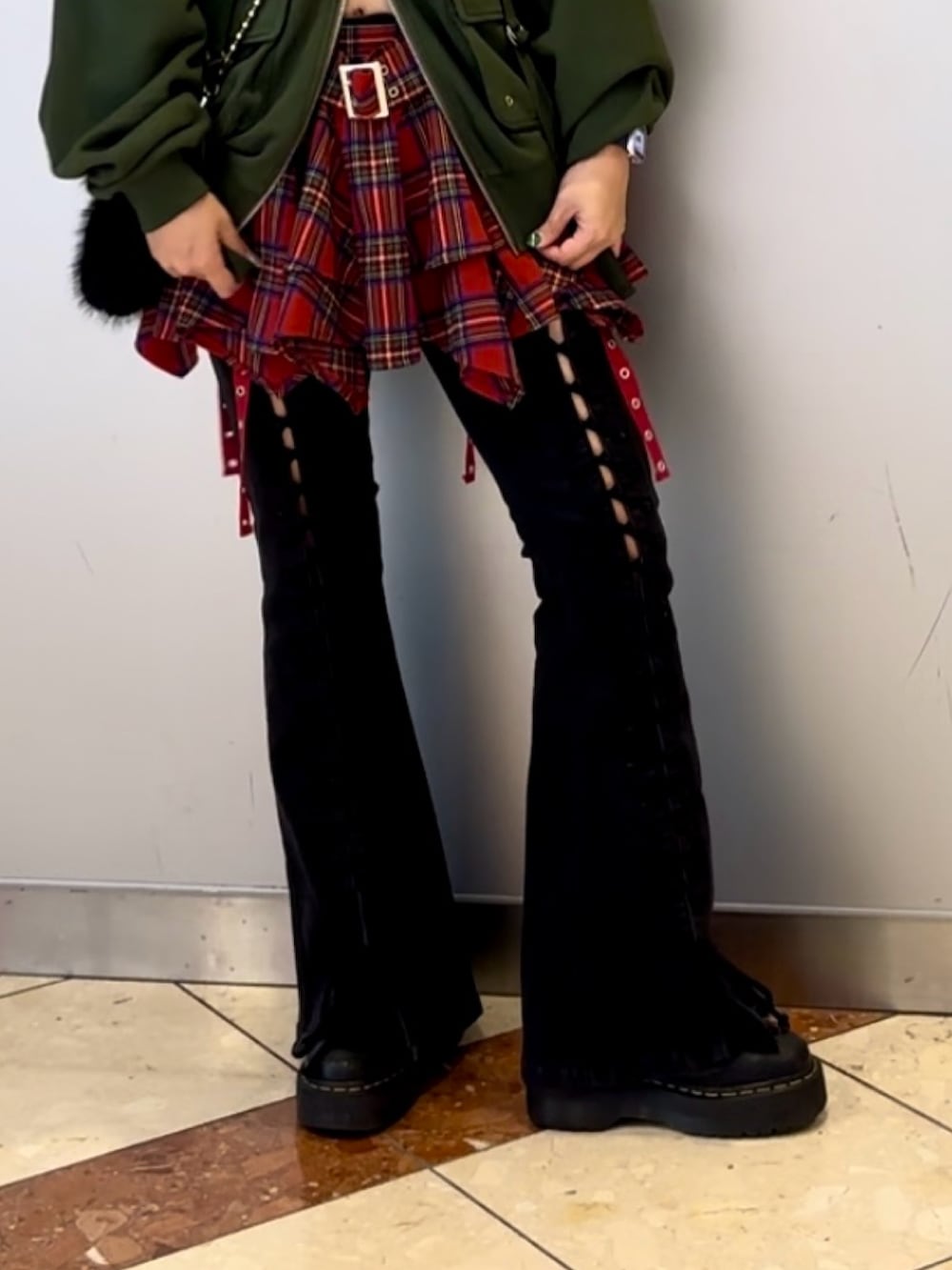 ブラック系のハンドバッグ、ブラック系のデニムパンツ、グリーン系のパーカーを着用したレディースの秋コーディネートの6枚目の写真