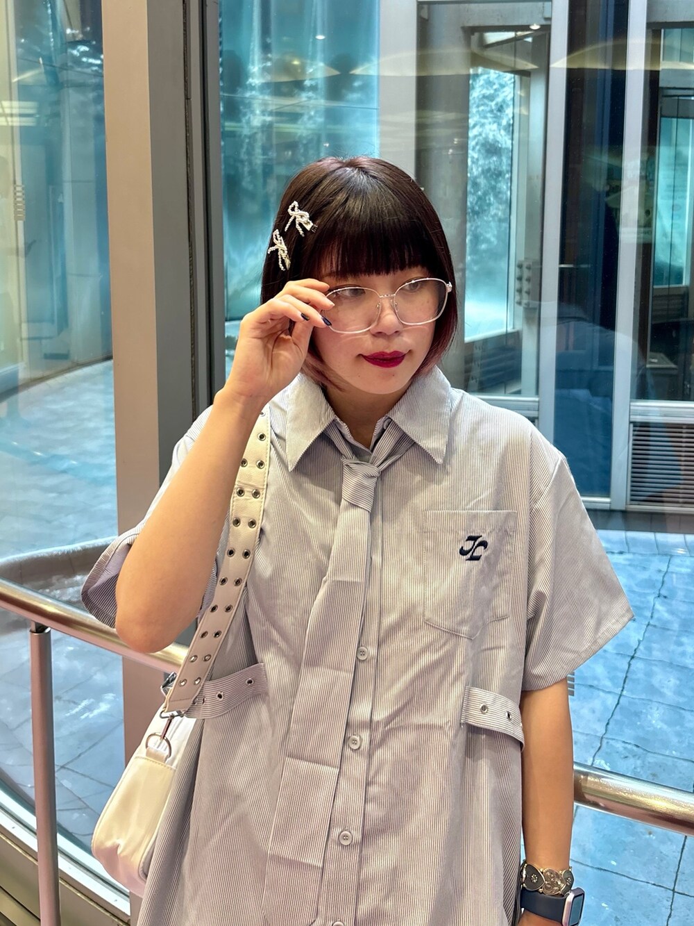 ブルー系のシャツ/ブラウス、ホワイト系のショルダーバッグ、ブラック系のデニムパンツを着用したレディースの夏コーディネートの5枚目の写真