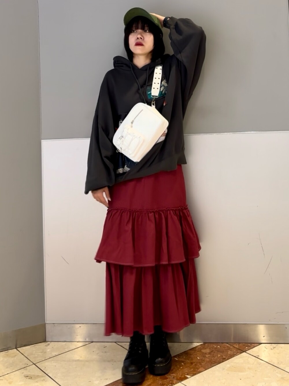 レッド系のワンピース、グレー系のパーカー、ホワイト系のショルダーバッグを着用したレディースの秋コーディネートの3枚目の写真