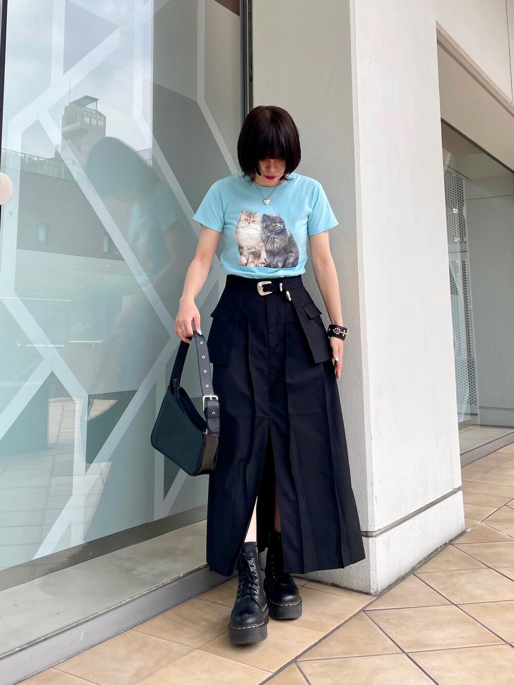 ブルー系のTシャツ/カットソー、ブラック系のスカート、シルバー系のハンドバッグを着用したレディースの春コーディネートの3枚目の写真