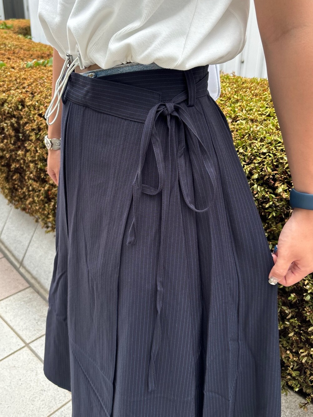 ブルー系のスカート、ホワイト系のショルダーバッグ、ホワイト系のTシャツ/カットソーを着用したレディースの夏コーディネートの9枚目の写真