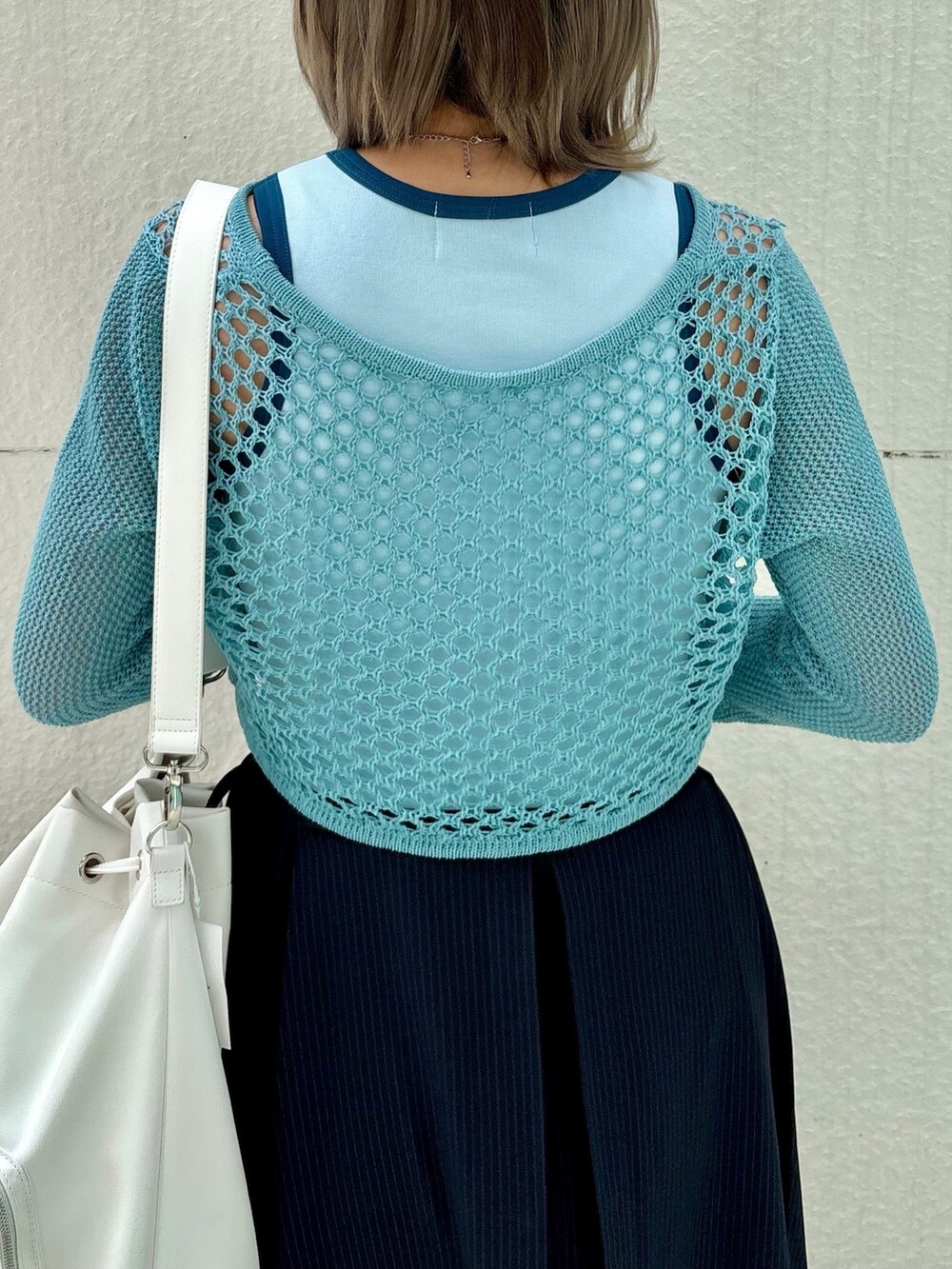 ブルー系のスカート、ブルー系のデニムパンツ、ブルー系のタンクトップを着用したレディースの春コーディネートの6枚目の写真