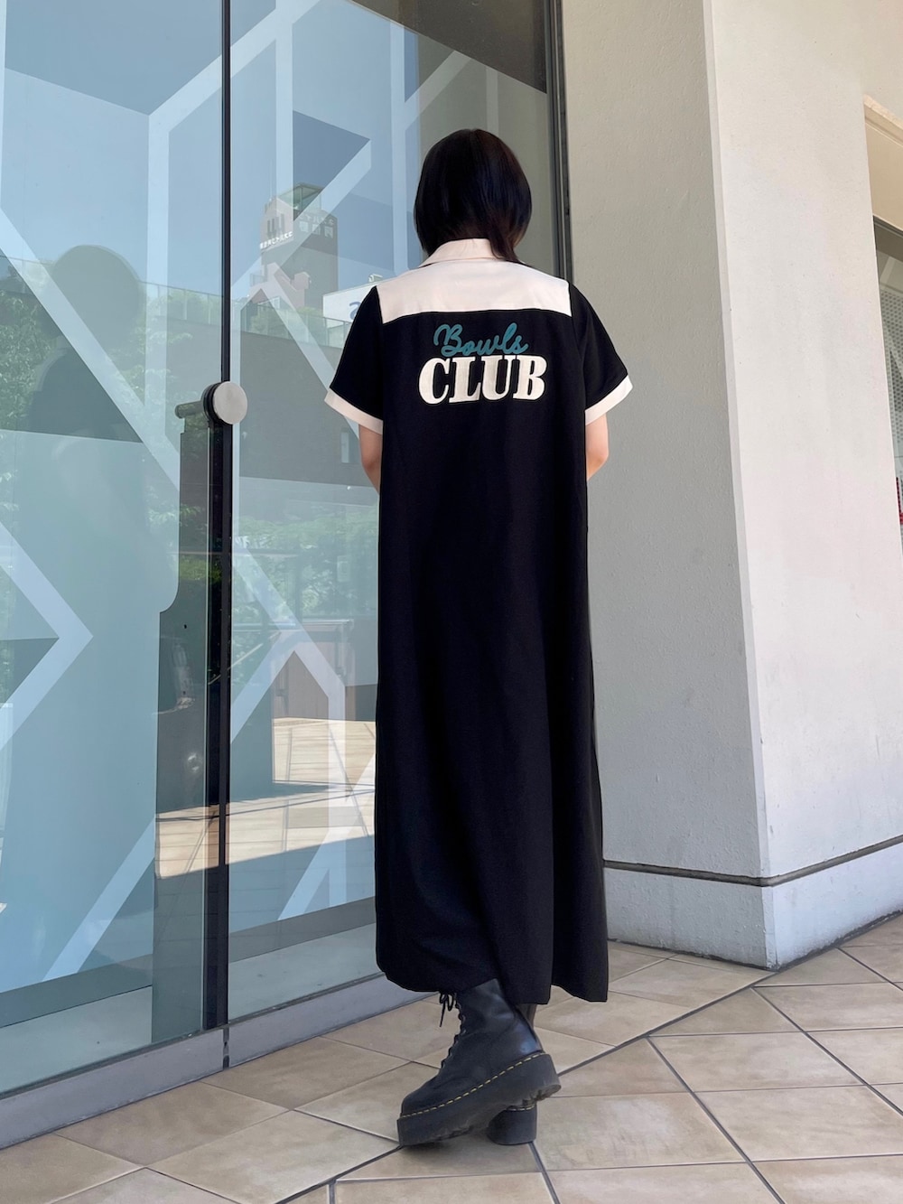 ブラック系のワンピース、ブラック系のボストンバッグ、レッド系のサングラスを着用したレディースの春コーディネートの9枚目の写真