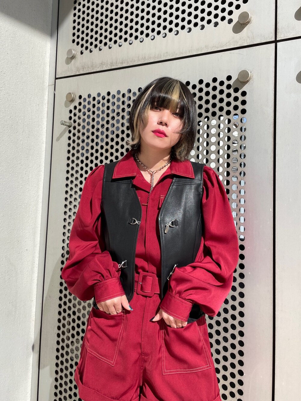 ブラック系のブーツ、ブラック系のベスト、レッド系のつなぎ/オールインワンを着用したレディースの春コーディネートの7枚目の写真