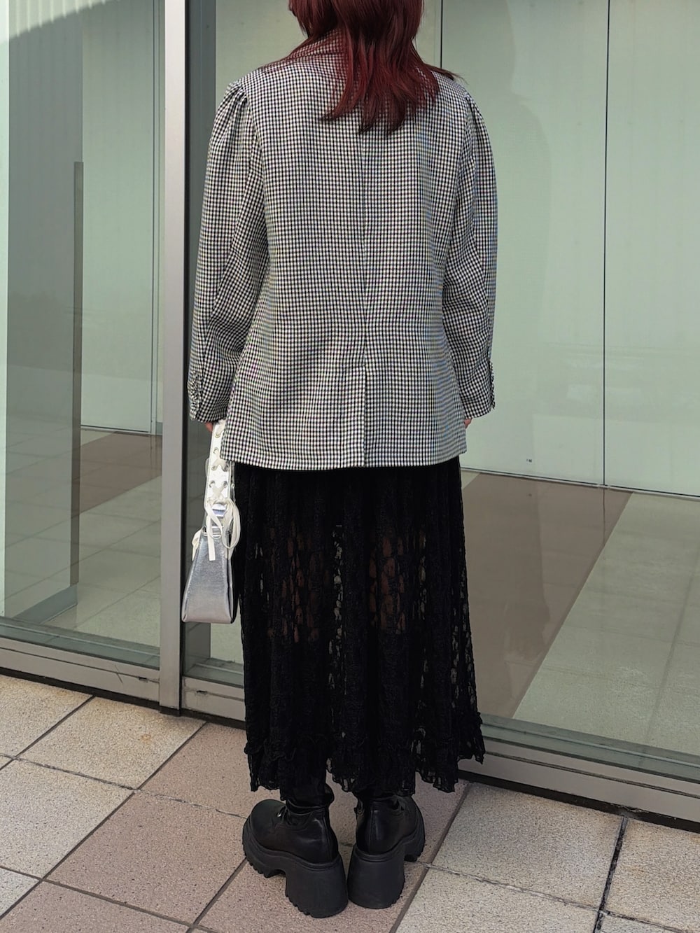 ブラック系のワンピース、ブラック系のテーラードジャケット、シルバー系のハンドバッグを着用したレディースの冬コーディネートの4枚目の写真