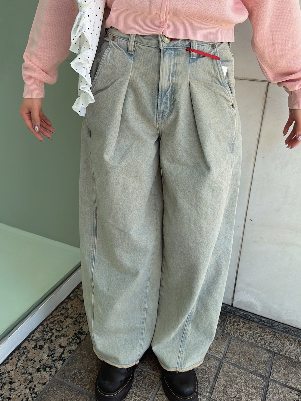 ピンク系のニット/セーター、ホワイト系のトートバッグ、ブルー系のデニムパンツを着用したレディースの春コーディネートの7枚目の写真