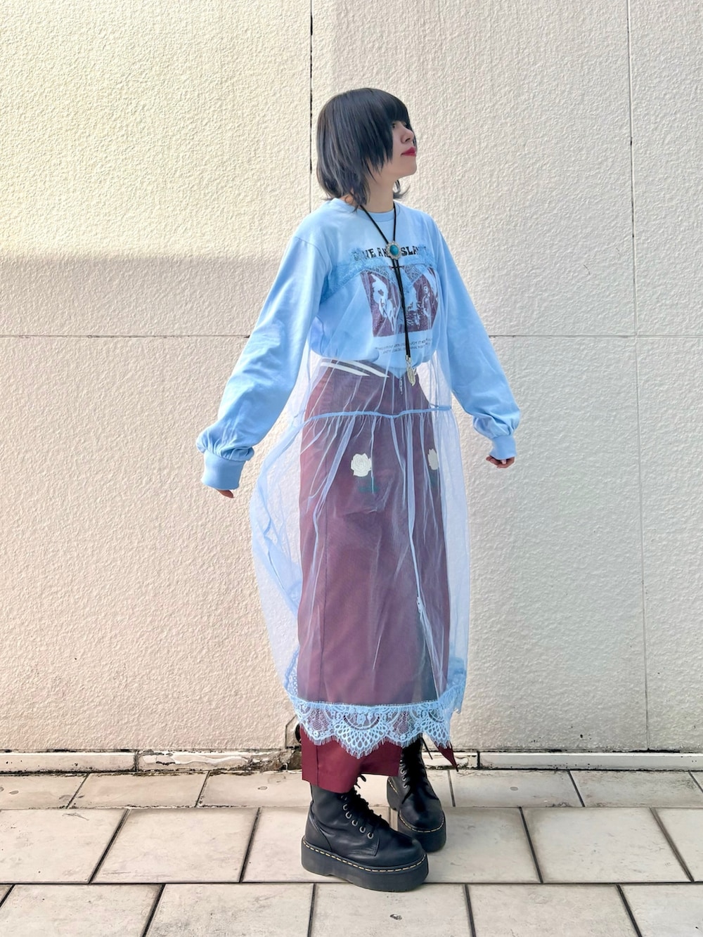 レッド系のスカート、ブルー系のワンピースを着用したレディースの冬コーディネートの4枚目の写真