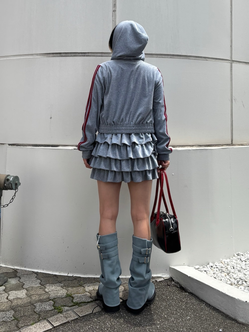 ブラック系のボストンバッグ、ブルー系のブーツ、ブラック系のTシャツ/カットソーを着用したレディースの春コーディネートの5枚目の写真