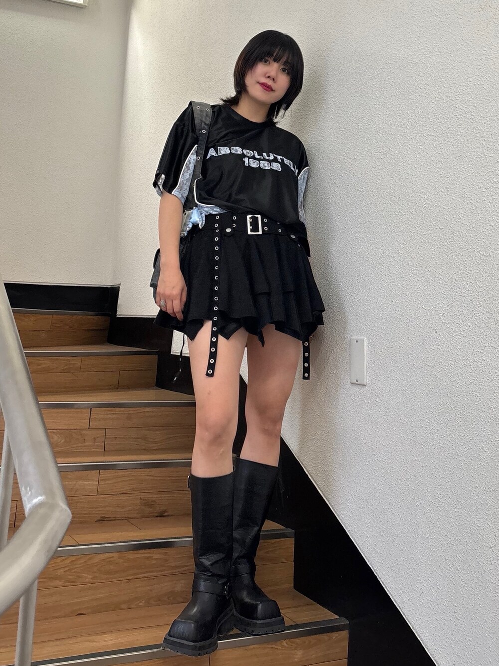 ブラック系のスカート、ブラック系のメッセンジャーバッグ、ブラック系のTシャツ/カットソーを着用したレディースの春コーディネートの2枚目の写真