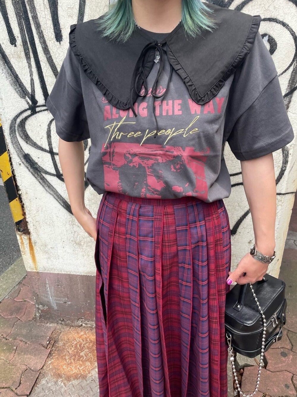 ブラック系のショルダーバッグ、ブラック系のTシャツ/カットソー、レッド系のスカートを着用したレディースの夏コーディネートの3枚目の写真