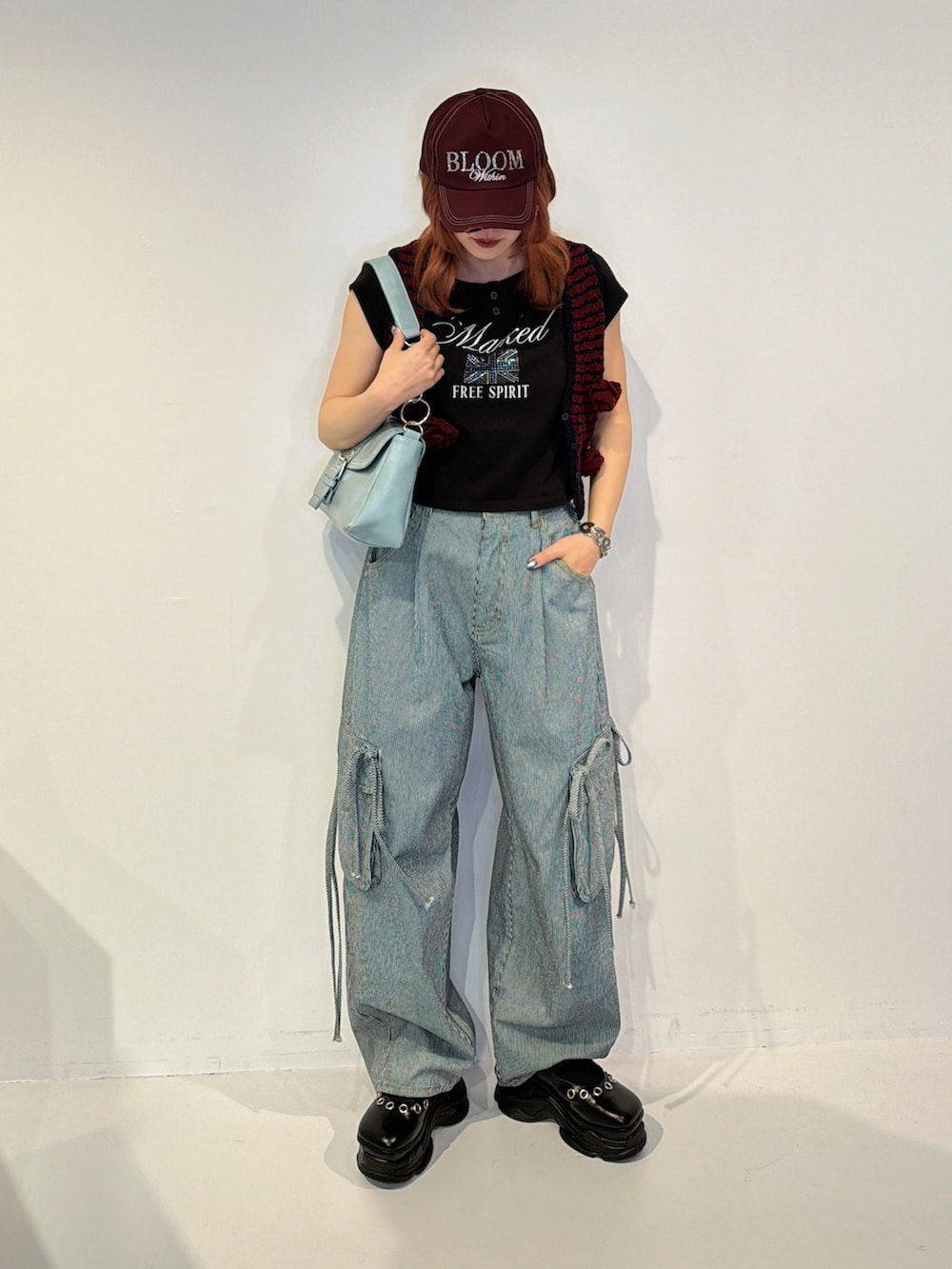 ブラック系のデニムパンツ、レッド系のその他トップスを着用したレディースの冬コーディネートの2枚目の写真