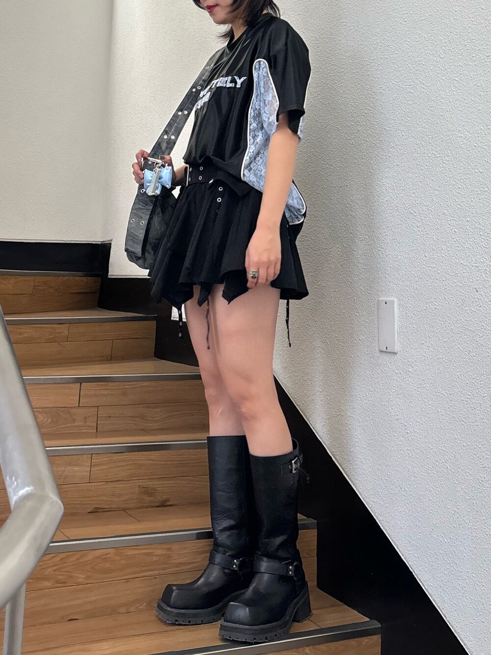 ブラック系のスカート、ブラック系のメッセンジャーバッグ、ブラック系のTシャツ/カットソーを着用したレディースの春コーディネートの10枚目の写真