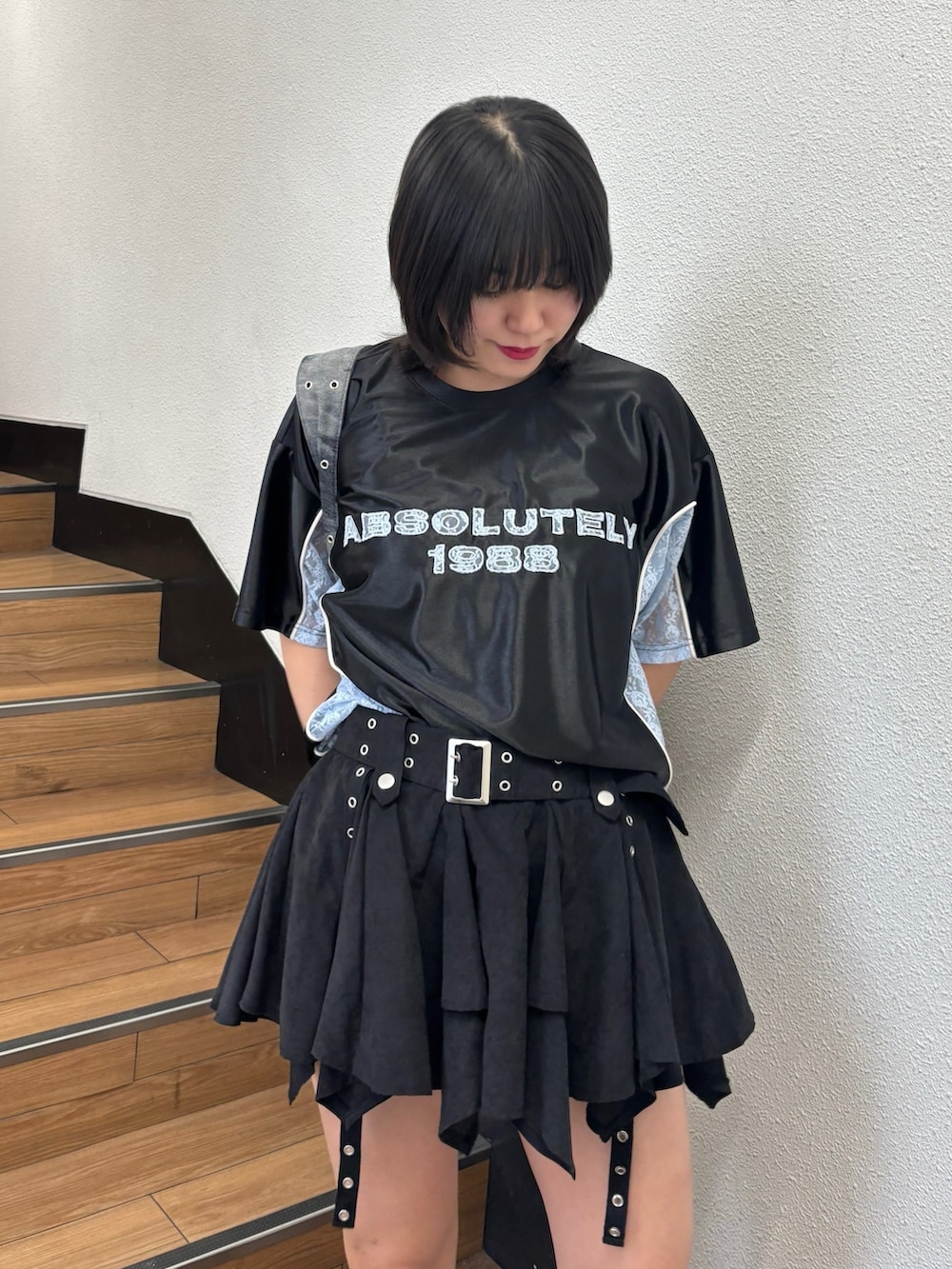 ブラック系のスカート、ブラック系のメッセンジャーバッグ、ブラック系のTシャツ/カットソーを着用したレディースの春コーディネートの5枚目の写真