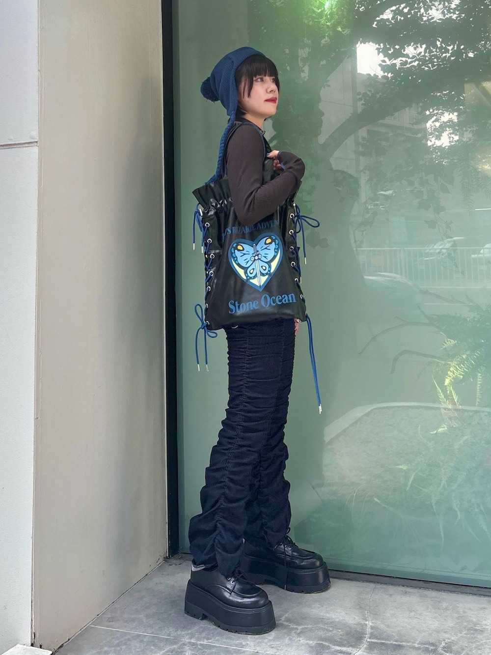 ブラック系のトートバッグ、ブルー系のデニムパンツ、ブラック系のTシャツ/カットソーを着用したレディースの秋コーディネートの4枚目の写真