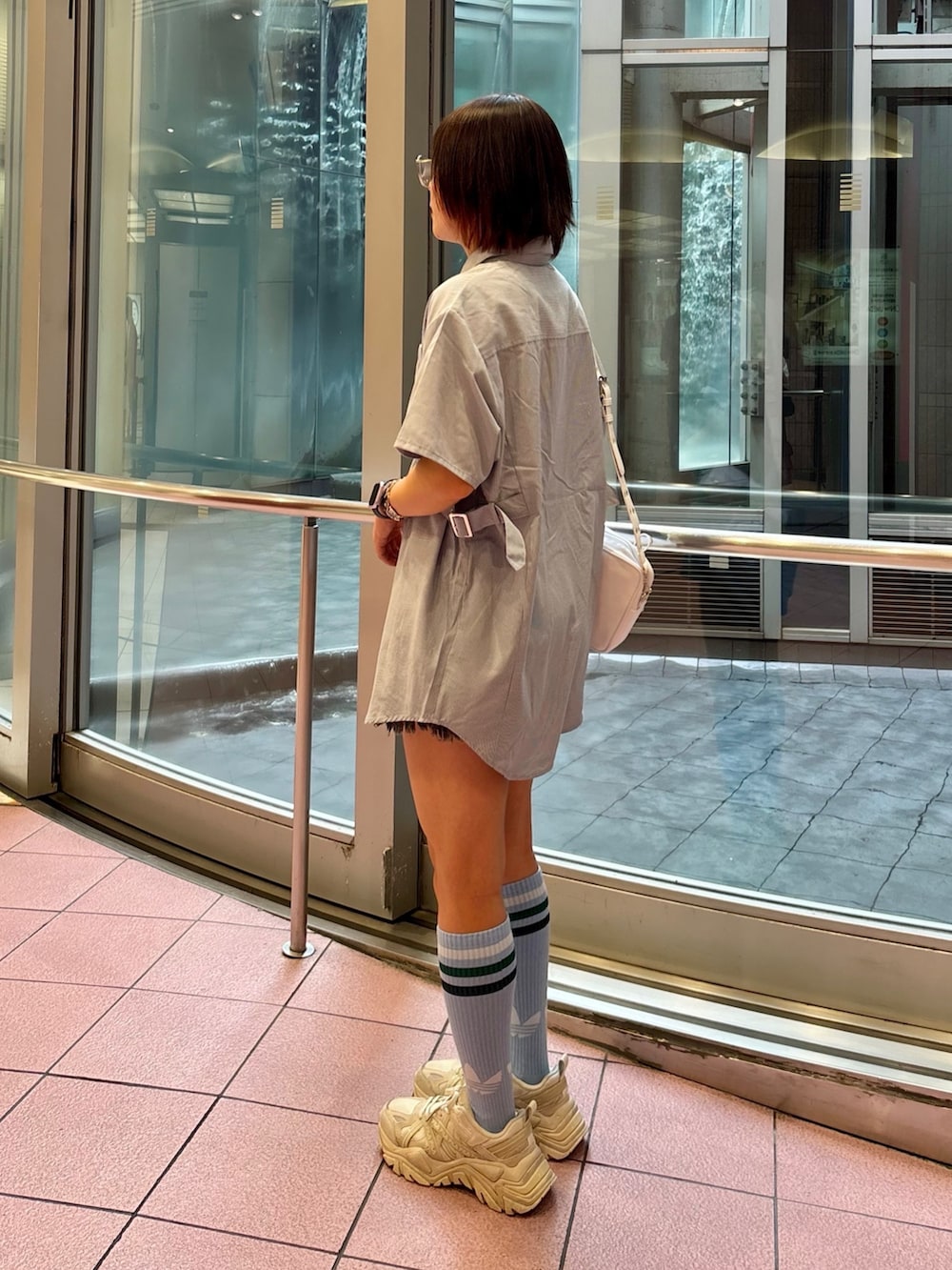 ブルー系のシャツ/ブラウス、ホワイト系のショルダーバッグ、ブラック系のデニムパンツを着用したレディースの夏コーディネートの4枚目の写真