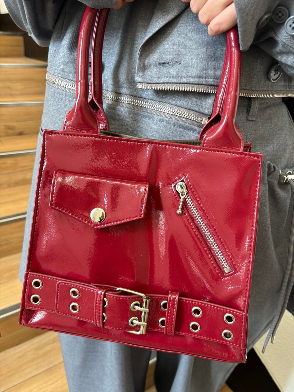 レッド系のハンドバッグ、レッド系のドレスシューズ、グレー系のテーラードジャケットを着用したレディースの夏コーディネートの9枚目の写真