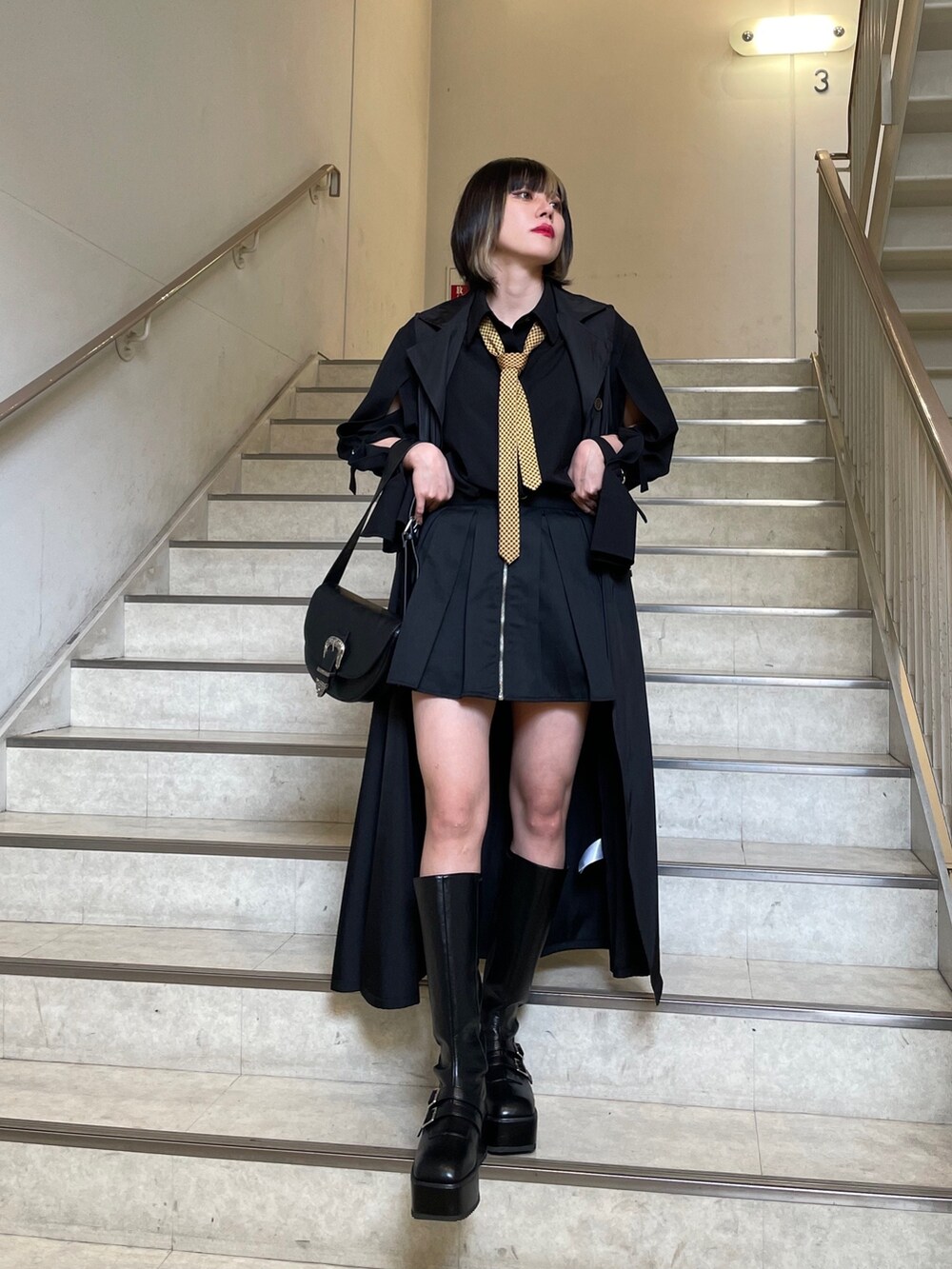 ブラック系のブーツ、ブラック系のシャツ/ブラウス、ブラック系のショルダーバッグを着用したレディースの春コーディネートの2枚目の写真