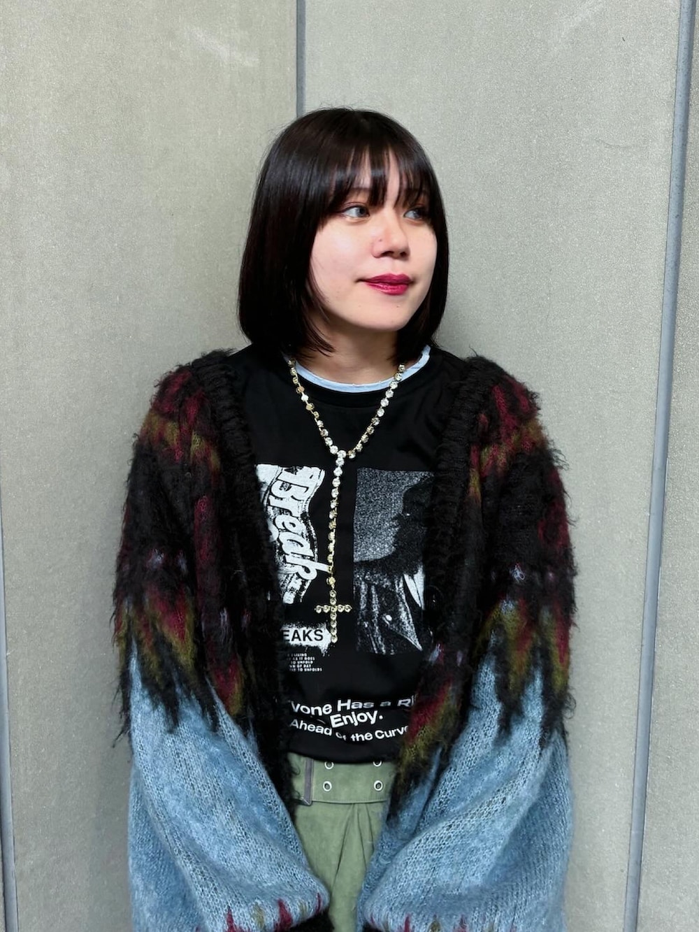 ブラック系のTシャツ/カットソー、ブラック系のカーディガン/ボレロ、グリーン系のスカートを着用したレディースの秋コーディネートの2枚目の写真