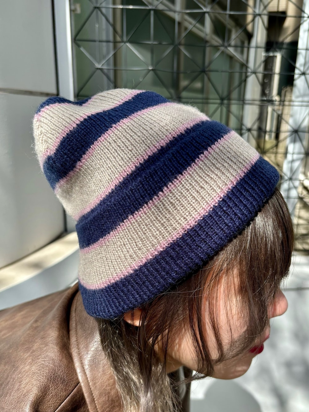 レッド系のハンドバッグ、レッド系のパンプス、ブラウン系のブルゾンを着用したレディースの夏コーディネートの10枚目の写真