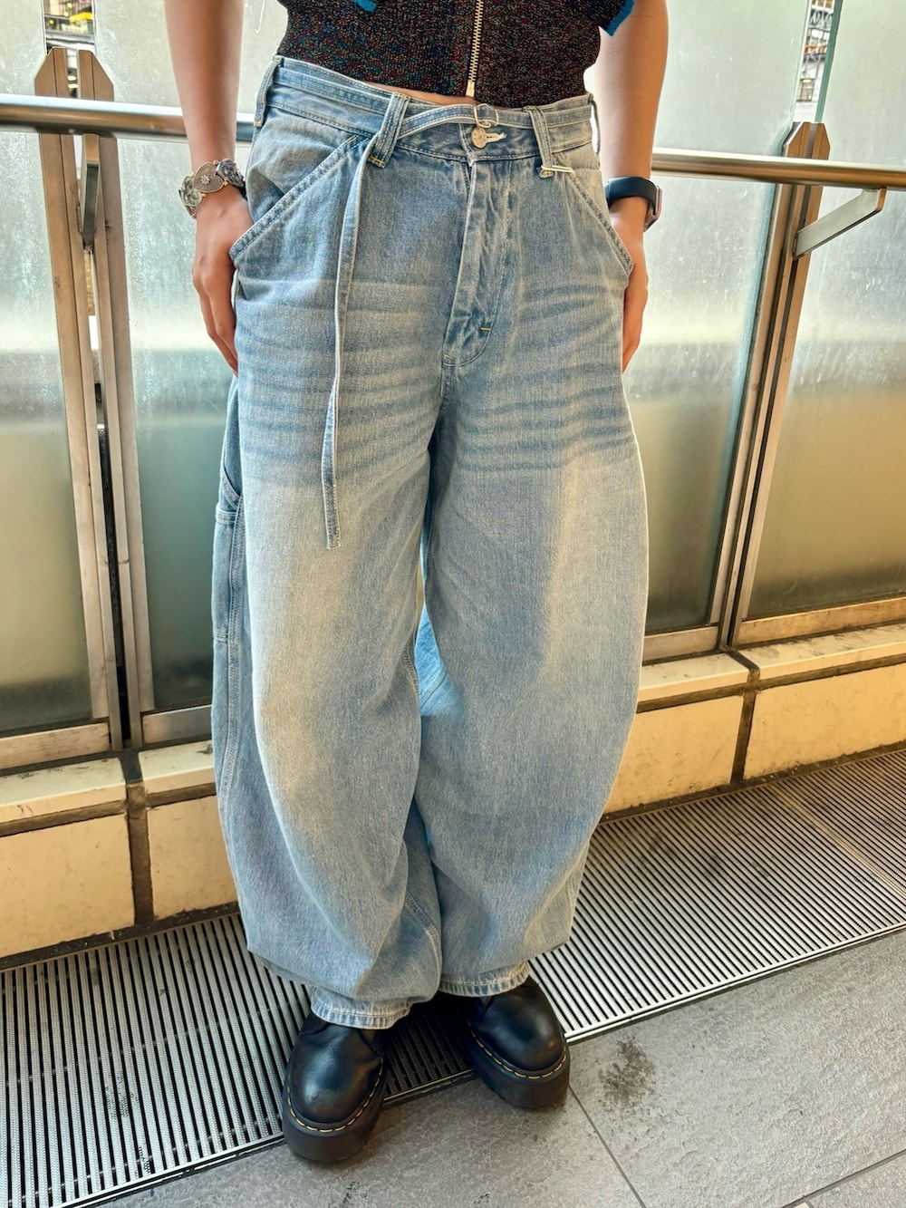 ブルー系のデニムパンツ、ブラック系のニット/セーター、シルバー系のブレスレットを着用したレディースの夏コーディネートの7枚目の写真