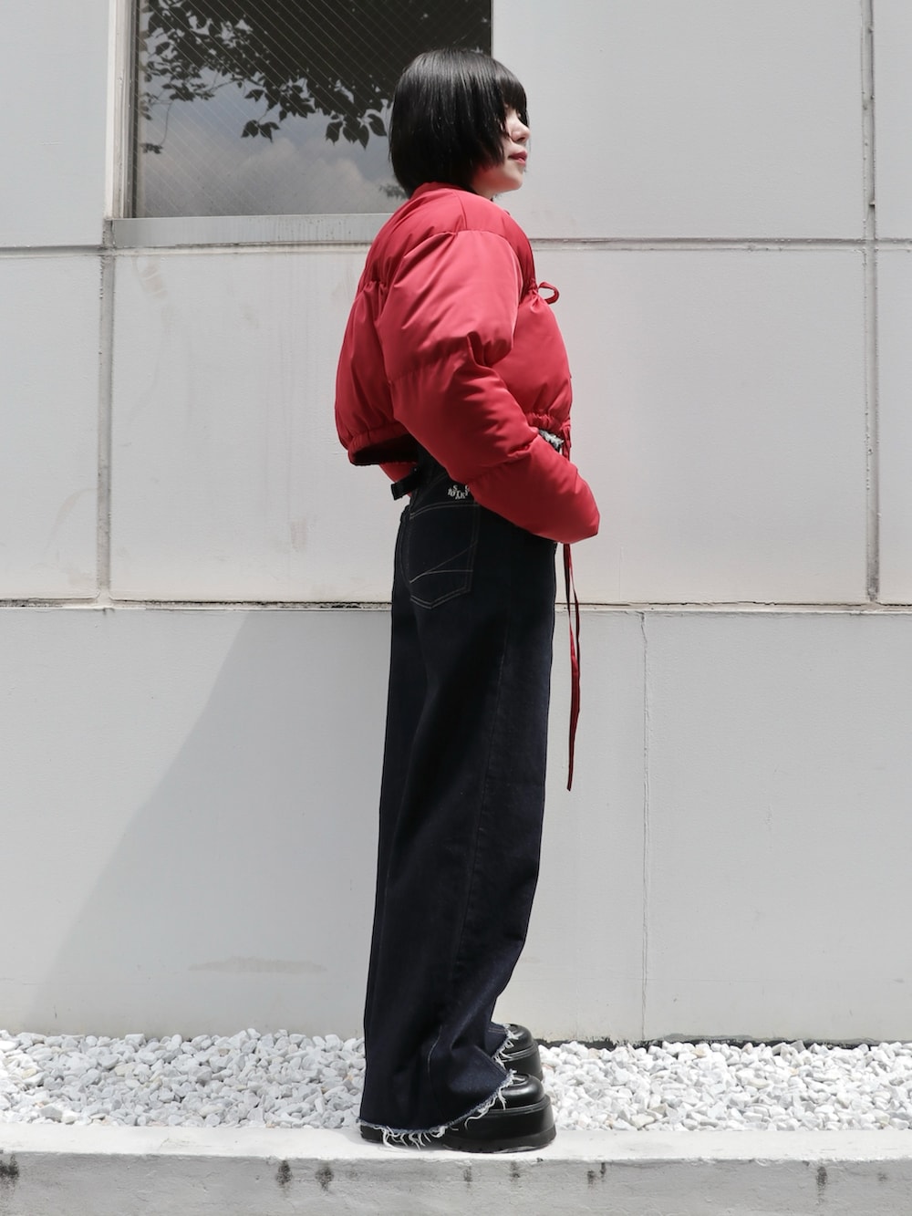 ブラック系のドレスシューズ、ブルー系のデニムパンツ、レッド系のブルゾンを着用したレディースの秋コーディネートの4枚目の写真