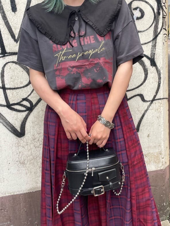 ブラック系のショルダーバッグ、ブラック系のTシャツ/カットソー、レッド系のスカートを着用したレディースの夏コーディネートの5枚目の写真