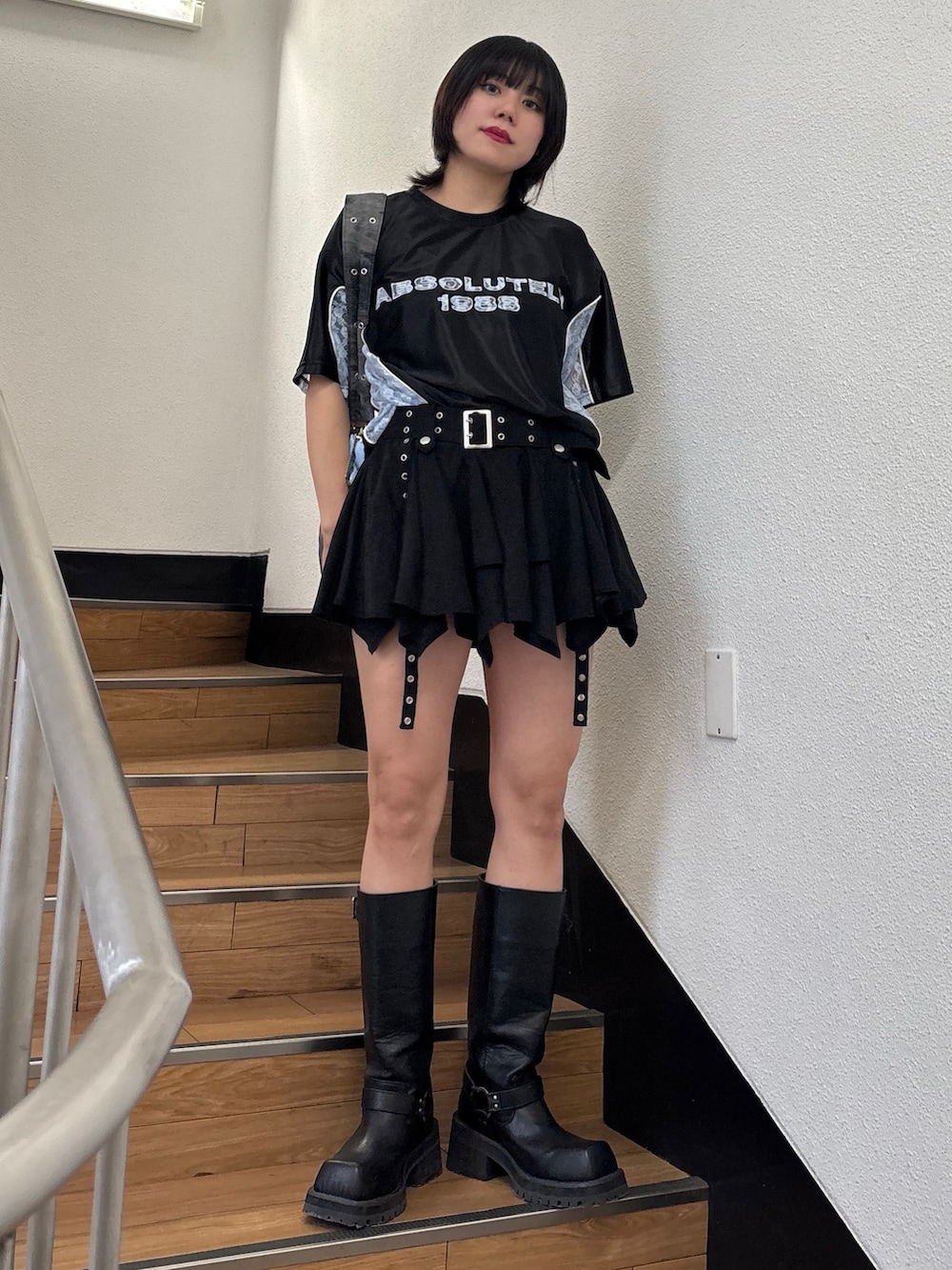 ブラック系のスカート、ブラック系のメッセンジャーバッグ、ブラック系のTシャツ/カットソーを着用したレディースの春コーディネートの3枚目の写真