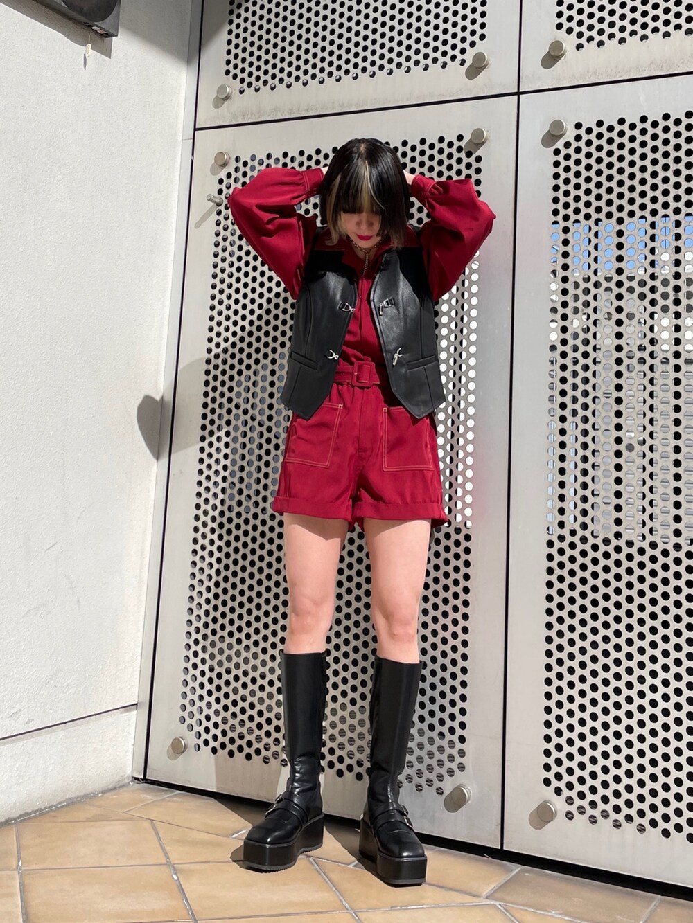 ブラック系のブーツ、ブラック系のベスト、レッド系のつなぎ/オールインワンを着用したレディースの春コーディネートの6枚目の写真