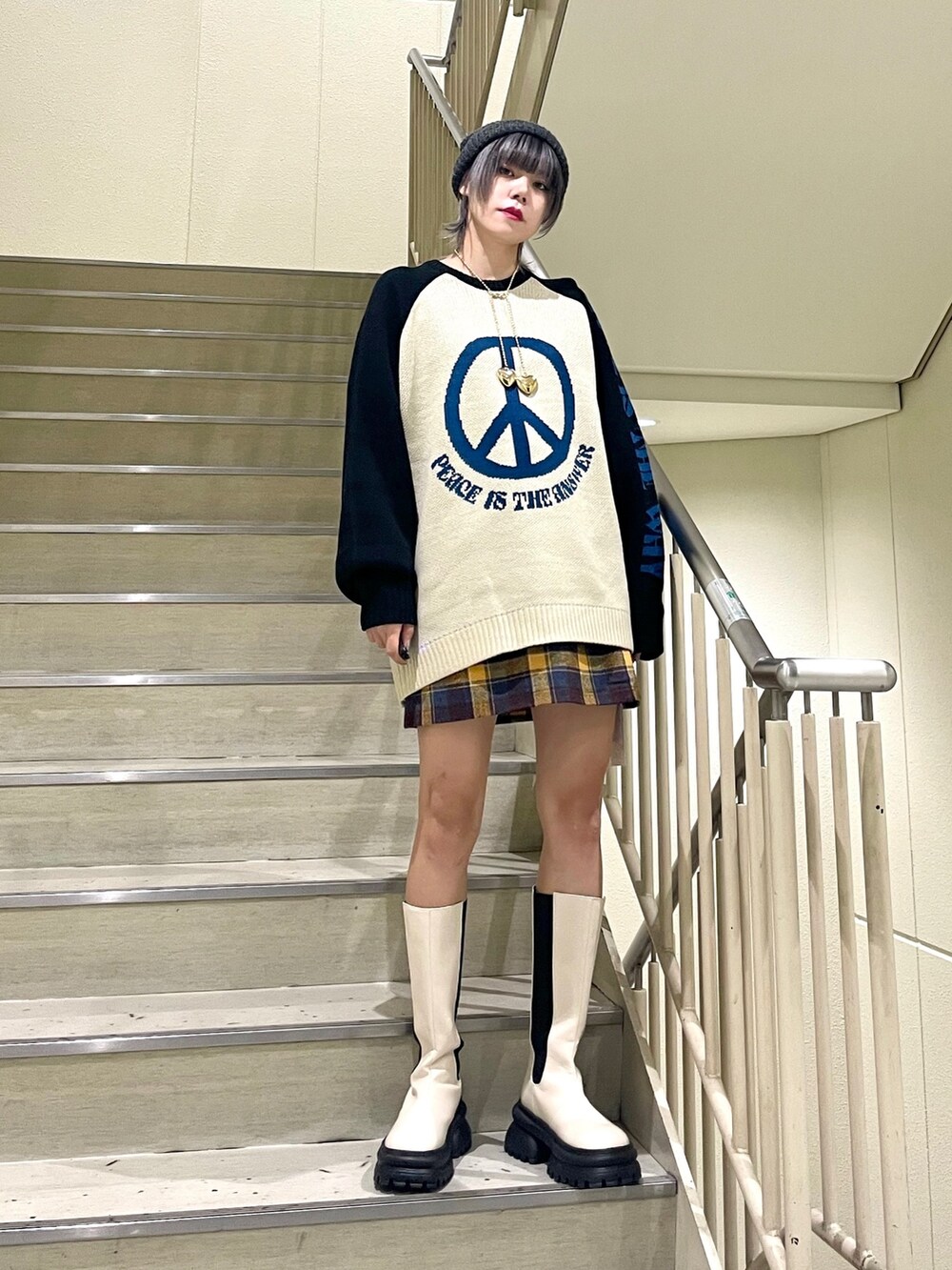 ブラック系のその他アウター、イエロー系のスカート、ホワイト系のブーツを着用したレディースの秋コーディネートの6枚目の写真