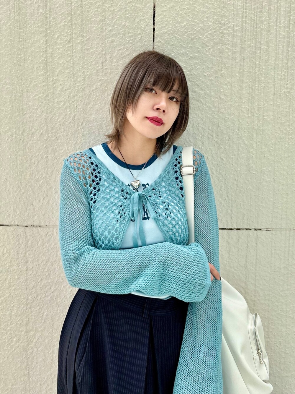 ブルー系のスカート、ブルー系のデニムパンツ、ブルー系のタンクトップを着用したレディースの春コーディネートの4枚目の写真