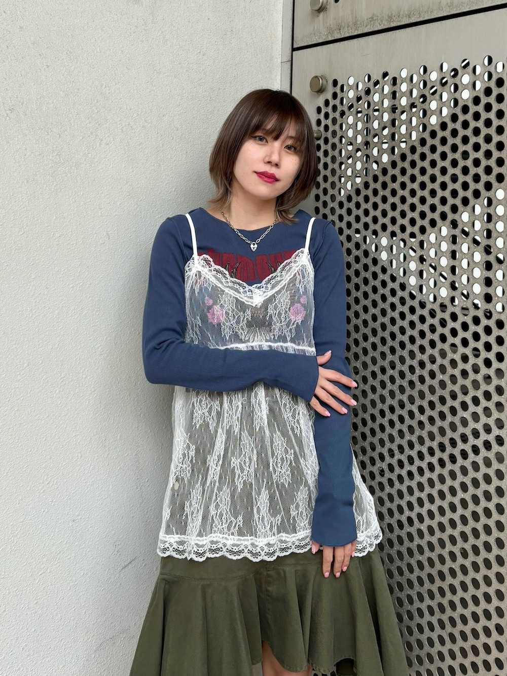 グリーン系のスカート、ブルー系のTシャツ/カットソー、ホワイト系のキャミソールを着用したレディースの冬コーディネートの6枚目の写真