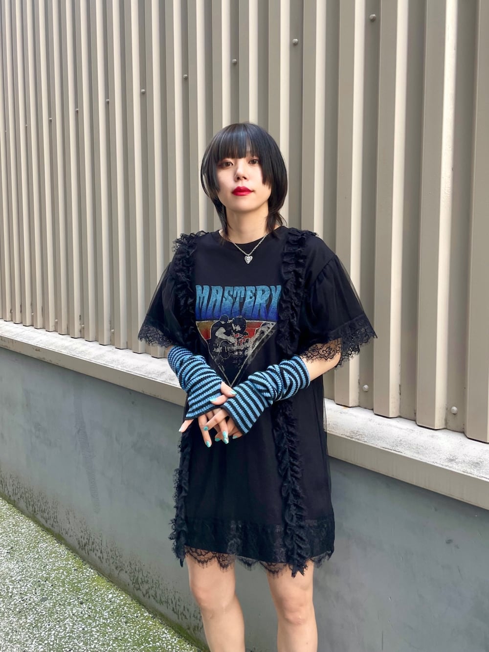 ブラック系のワンピース、ブルー系のアームカバー、シルバー系のネックレスを着用したレディースの春コーディネートの7枚目の写真