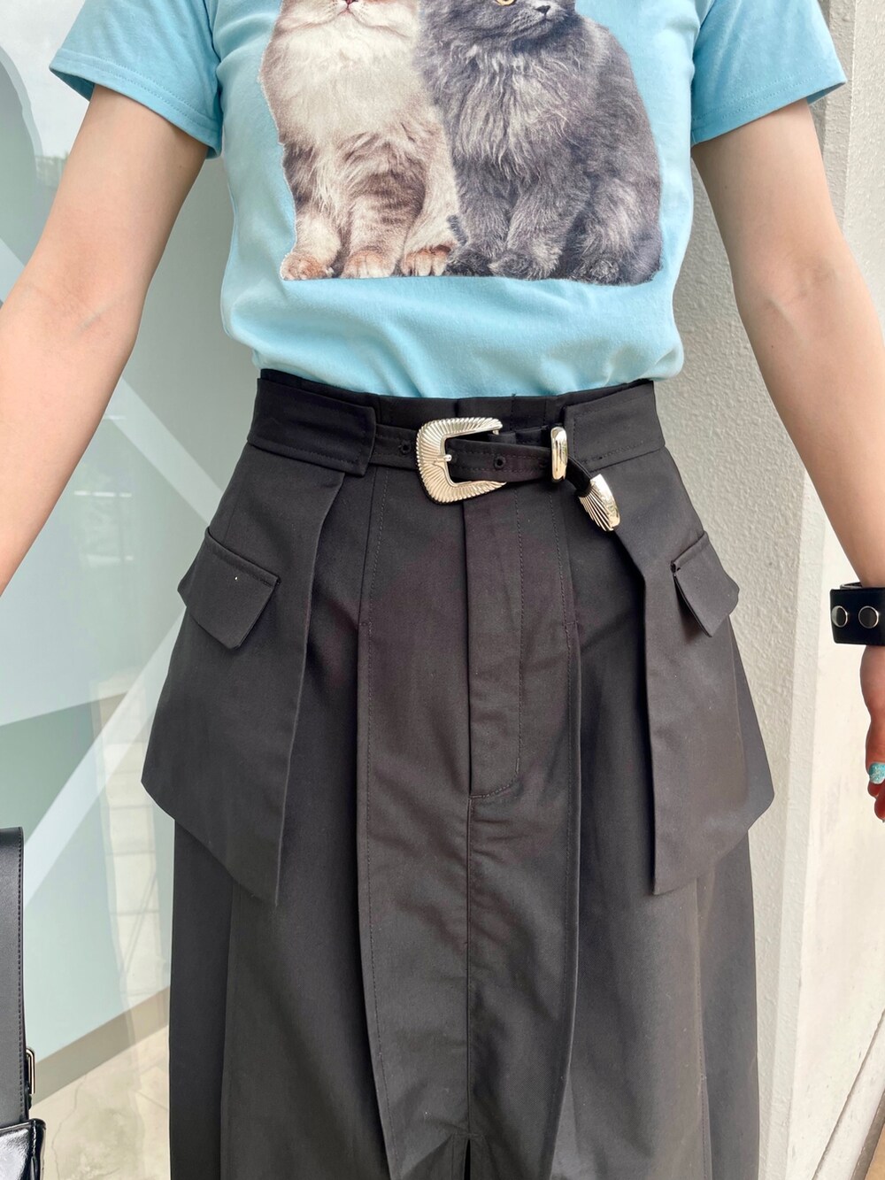 ブルー系のTシャツ/カットソー、ブラック系のスカート、シルバー系のハンドバッグを着用したレディースの春コーディネートの7枚目の写真