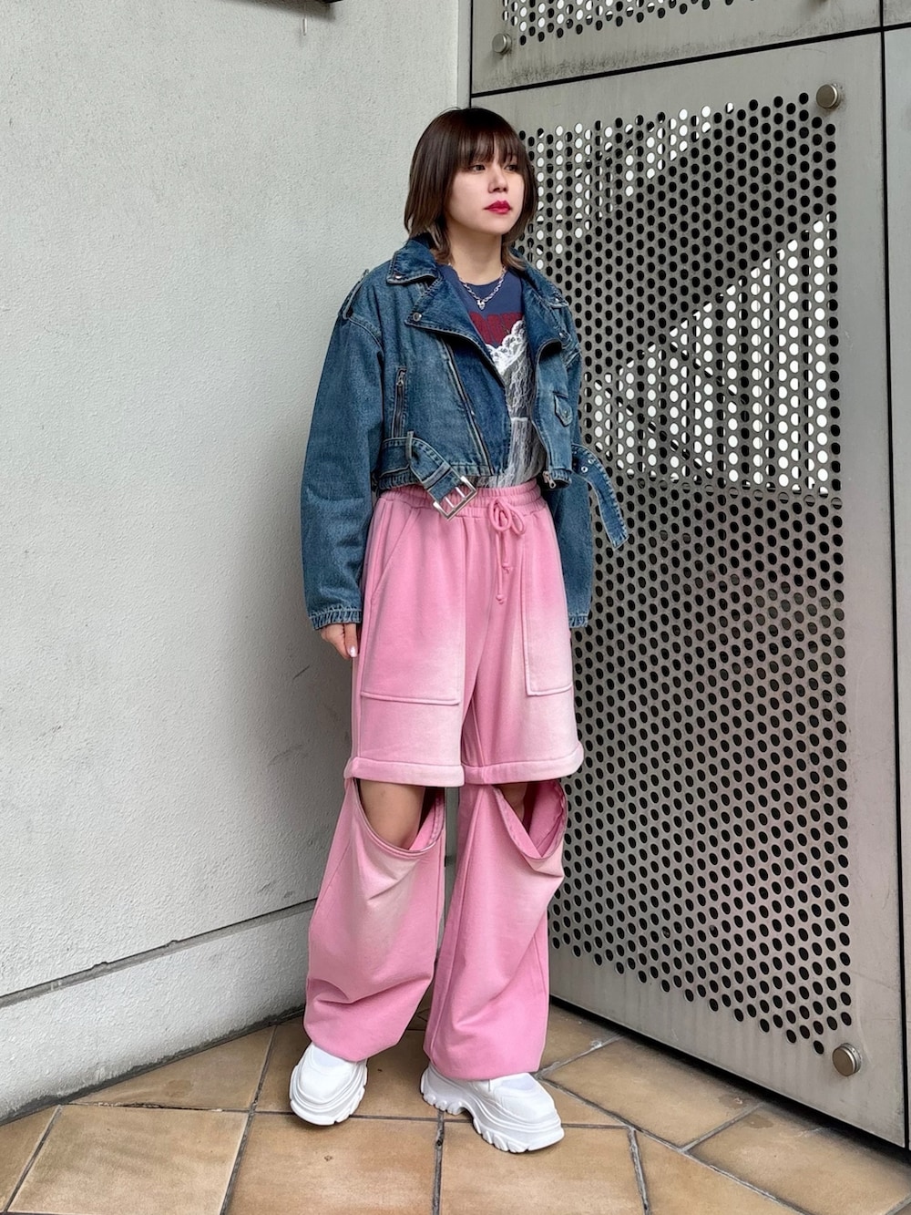 ホワイト系のスニーカー、ピンク系のスウェットパンツ、ブルー系のライダースジャケットを着用したレディースの春コーディネートの5枚目の写真