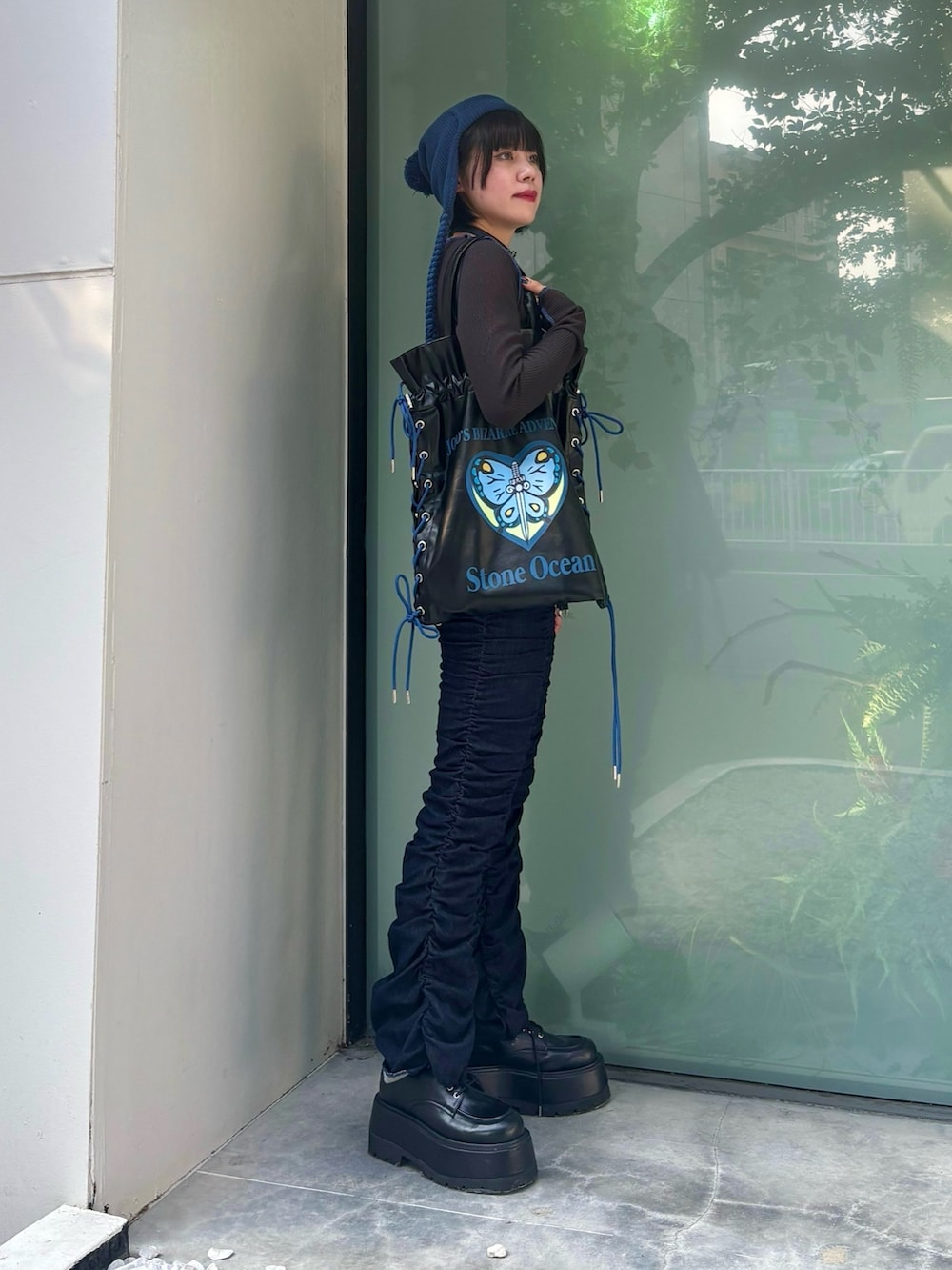 ブラック系のトートバッグ、ブルー系のデニムパンツ、ブラック系のTシャツ/カットソーを着用したレディースの秋コーディネートの3枚目の写真