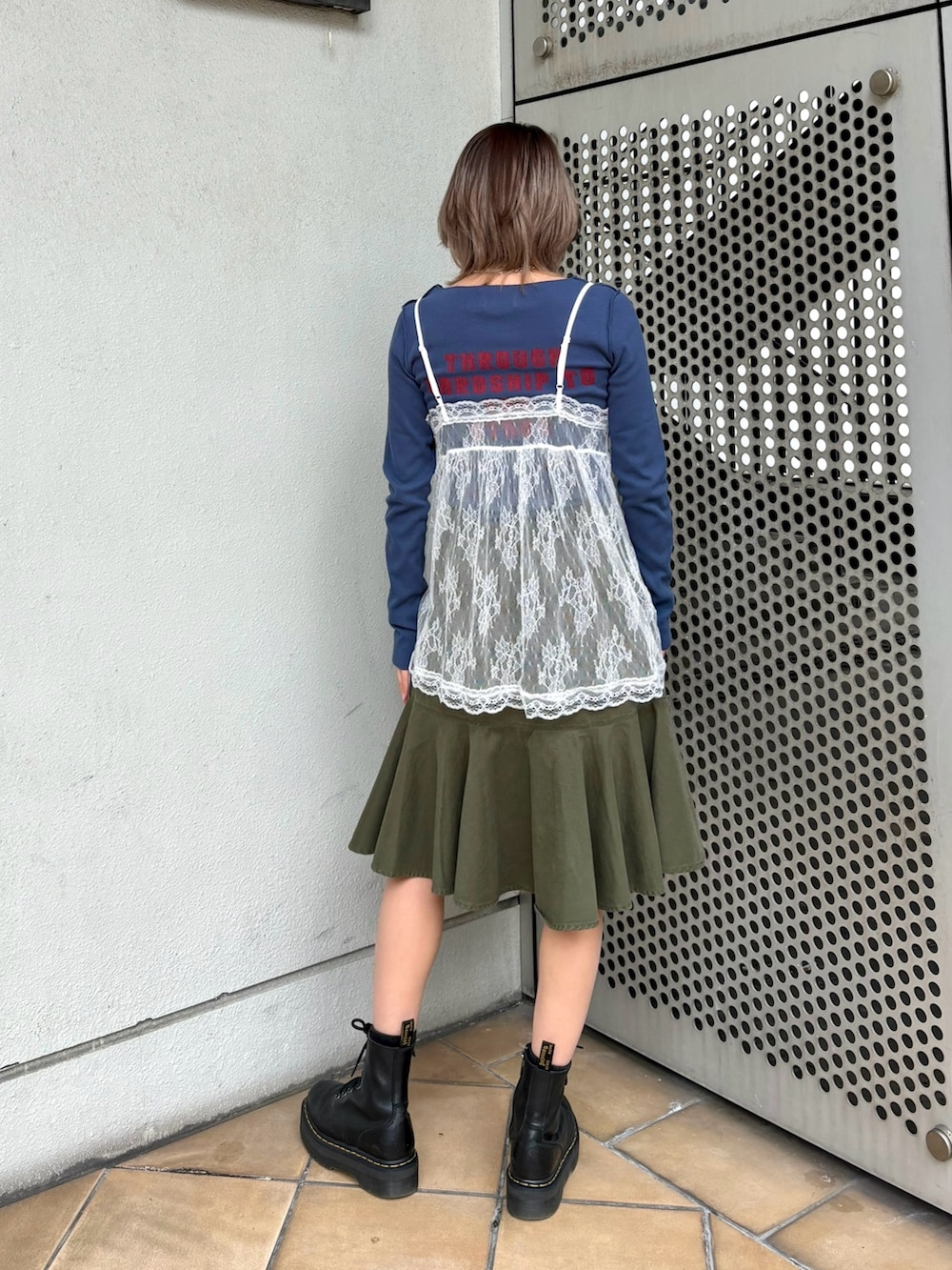 グリーン系のスカート、ブルー系のTシャツ/カットソー、ホワイト系のキャミソールを着用したレディースの冬コーディネートの5枚目の写真